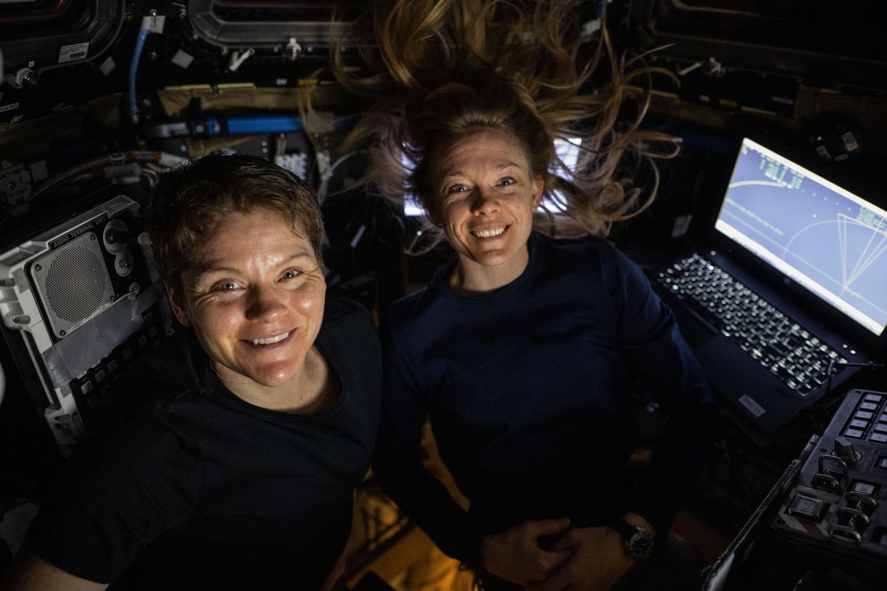 iss073e0249126 (June 26, 2025) --- NASA astronauts (from left) Anne McClain and Nichole Ayers, both Expedition 73 flight engineers, pose for a portrait inside the cupola while monitoring the SpaceX Dragon spacecraft carrying the Axiom Mission 4 crew as it approaches the International Space Station.