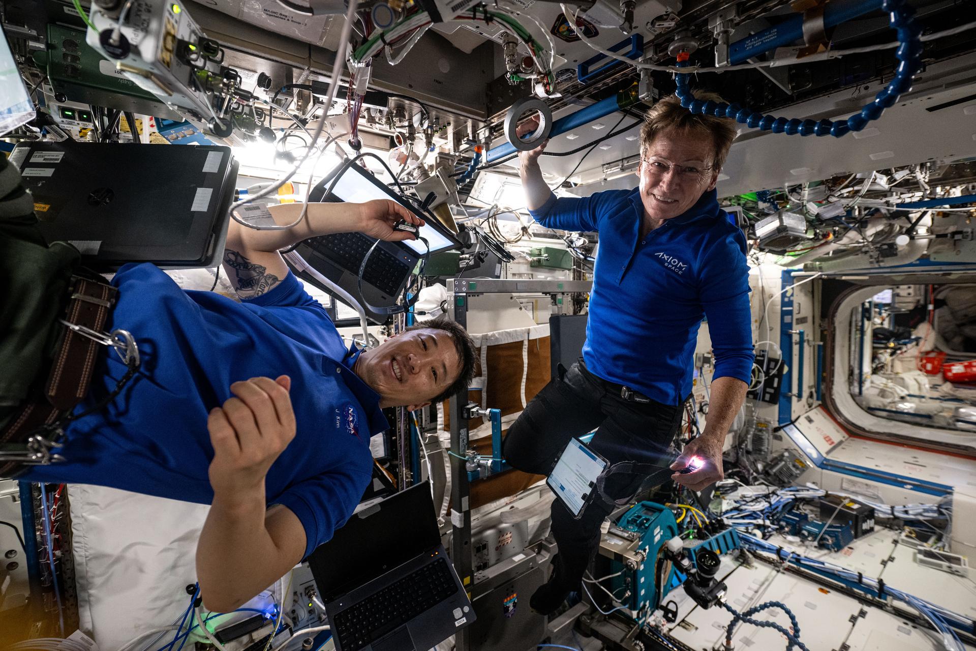 Expedition 73 Flight Engineer Jonny Kim from NASA and Axiom Mission 4 Commander Peggy Whitson work together inside the International Space Station's Destiny laboratory module setting up research hardware to culture patient-derived cancer cells, model their growth in microgravity, and test a state-of-the-art fluorescence microscope. Results may lead to earlier cancer detection methods, development of advanced cancer treatments, and promote future stem cell research in space.