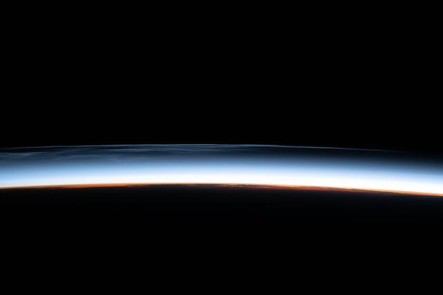 NASA image: Noctilucent clouds are pictured above the North Pacific Ocean