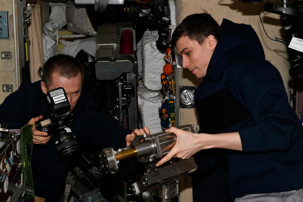 iss073e0257842 (July 8, 2025) --- Roscosmos cosmonauts (from left) Sergey Ryzhikov and Alexey Zubritsky, both Expedition 73 flight engineers, join each other and photograph treadmill components for inspection inside the International Space Station's Zvezda service module. Credit: Roscosmos