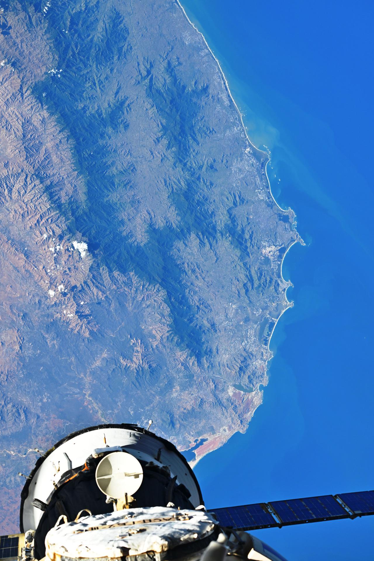 The southern coast of Madagascar is pictured 261 miles below the International Space Station with a portion of the Soyuz MS-27 spacecraft docked to the Poisk module in the lower foreground. Credit: Roscosmos