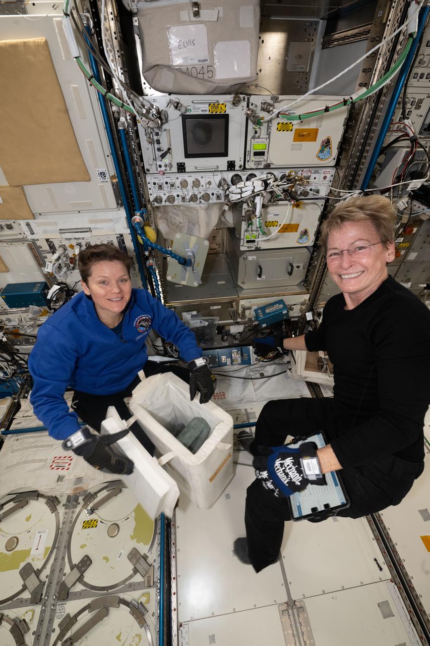 iss073e0284872 (July 12, 2025) --- (From left) Expedition 73 Flight Engineer Anne McClain of NASA helps Axiom Mission 4 Commander Peggy Whitson from Axiom Space pack frozen research samples aboard the International Space Station before loading them inside the SpaceX Dragon crew spacecraft for return to Earth.