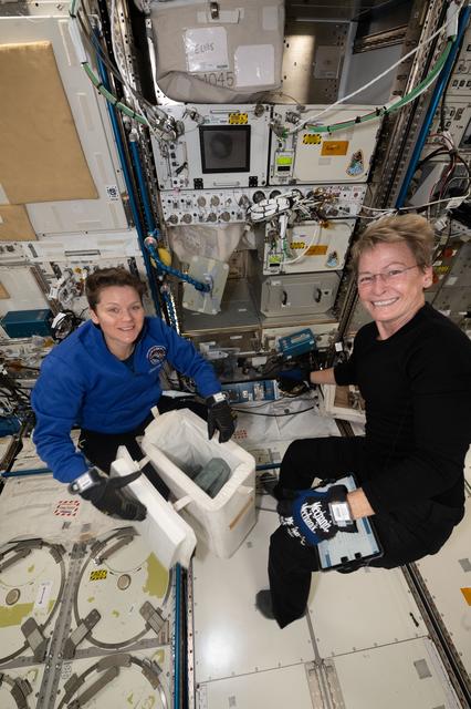 NASA image: Astronauts Anne McClain and Peggy Whitson pack frozen research samples