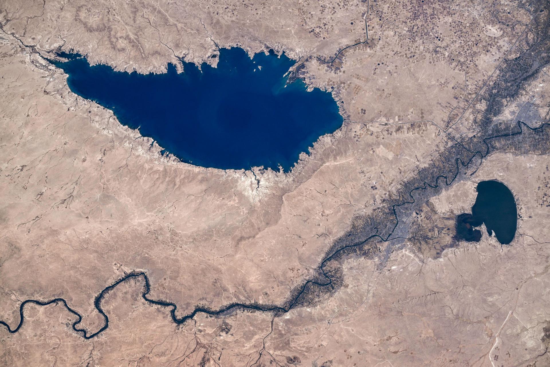 The Euphrates River runs in between the large, artificial Lake Tharthar and the small Lake Habbaniyah to the northwest of Baghdad, Iraq, in this photograph from the International Space Station as it orbited 260 miles above the Middle Eastern nation. Credit: Roscosmos