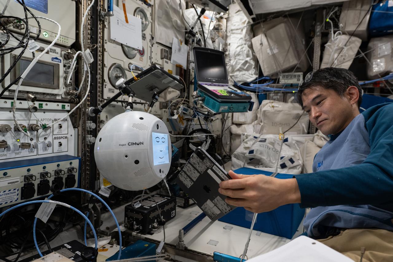 iss073e0384102 (July 18, 2025) --- JAXA (Japan Aerospace Exploration Agency) astronaut and Expedition 73 Commander Takuya Onishi sets up the CIMON artificial intelligence-powered robotic assistant inside the International Space Station's Kibo laboratory module. Engineers on the ground tested CIMON's ability to command a free-flying robotic camera for JAXA’s ICHIBAN technology demonstration. CIMON tests how artificial intelligence affects crew support potentially relieving crews for more important tasks and increasing time for relaxation during long-term missions.
