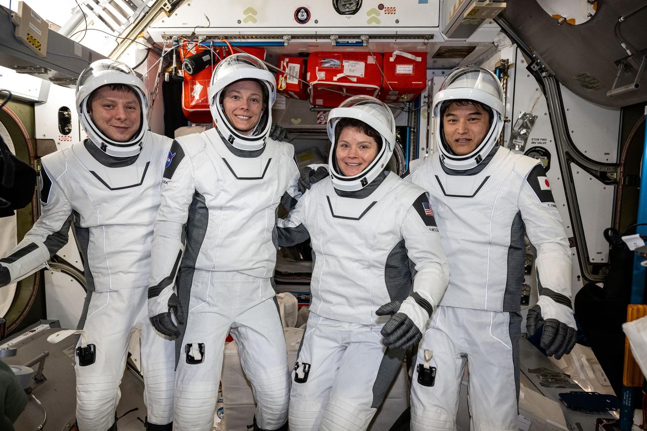 iss073e0414510 (July 29, 2025) --- The four members of NASA's SpaceX Crew-10 mission pose for a portrait in their Dragon pressure suits aboard the International Space Station's Harmony module. The Commercial Crew members were testing their suits' components and ensuring a proper fit before their departure on Aug. 8, 2025, aboard Dragon ending their five-month space research mission inside the orbital outpost. From left are, Roscosmos cosmonaut Kirill Peskov, NASA astronauts Nichole Ayers and Anne McClain, and JAXA (Japan Aerospace Exploration Agency) astronaut Takuya Onishi.