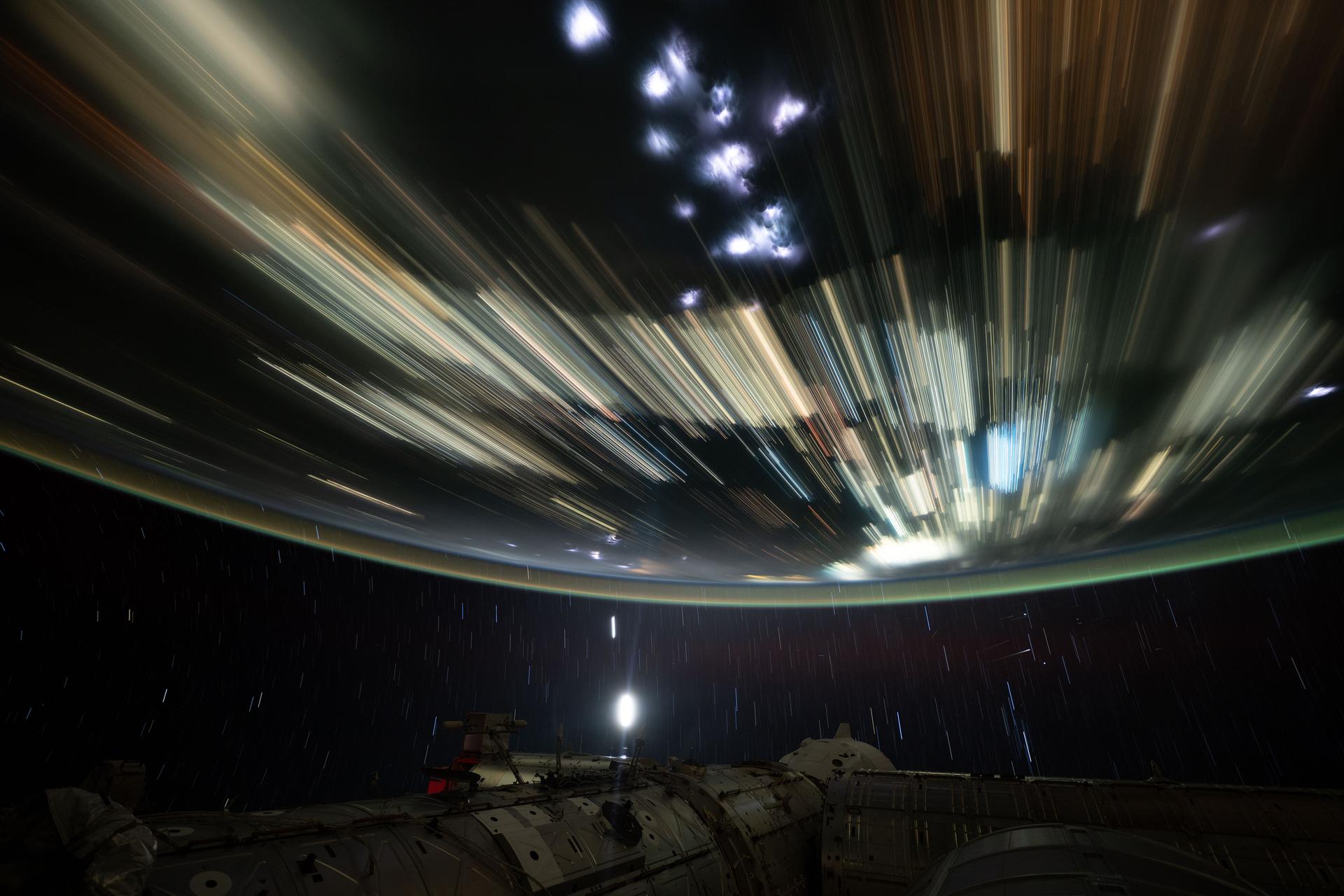 The International Space Station soars 259 miles above Cambodia in this long-duration photograph revealing star trails, lightning storms, and the city lights of Southeast Asia streaking below.