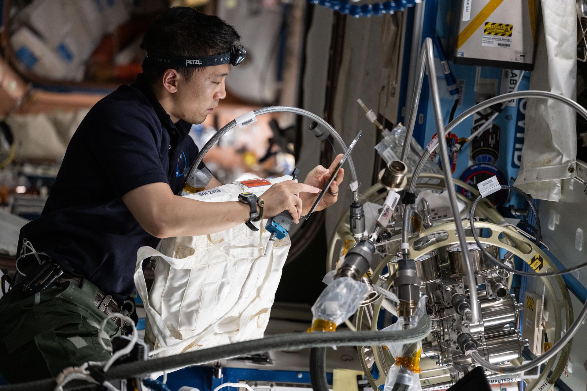 NASA astronaut and Expedition 73 Flight Engineer Jonny Kim performs maintenance on the Destiny laboratory module's fluid servicer system used to maintain and repair rack water lines and systems throughout the International Space Station.