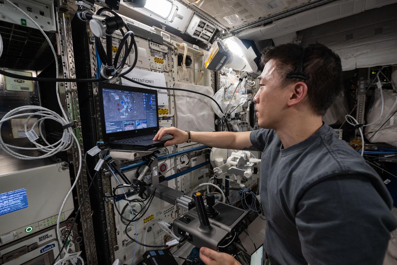 iss073e0416906 (July 21, 2025) --- NASA astronaut and Expedition 73 Flight Engineer Jonny Kim tests space-to-ground robotic controlling methods on a laptop computer inside the International Space Station's Columbus laboratory module. The Surface Avatar experiment explores ways to control robotic vehicles on a planetary surface from an orbiting spacecraft using a variety of technologies including consoles, touchscreens, haptics, and virtual reality goggles that may benefit future space exploration.