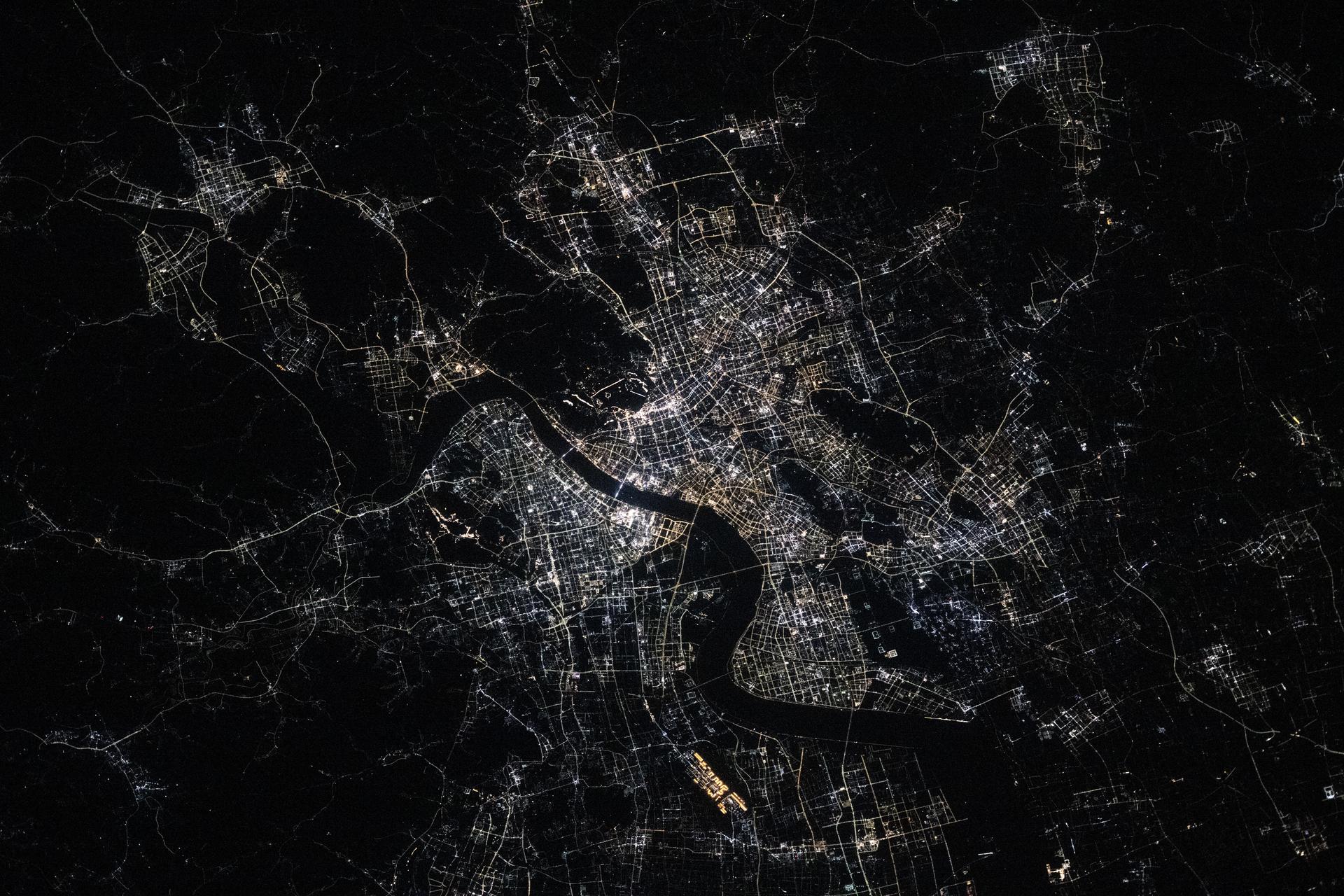 Hangzhou, China—home to approximately 13 million people and the southern end of the Grand Canal, the longest artificial river in the world—glows in this nighttime view from the International Space Station. The canal stretches over 1,200 miles from its starting point in Beijing. This photograph was taken at approximately 9:55 p.m. local time while the station was orbiting 259 miles above Earth.