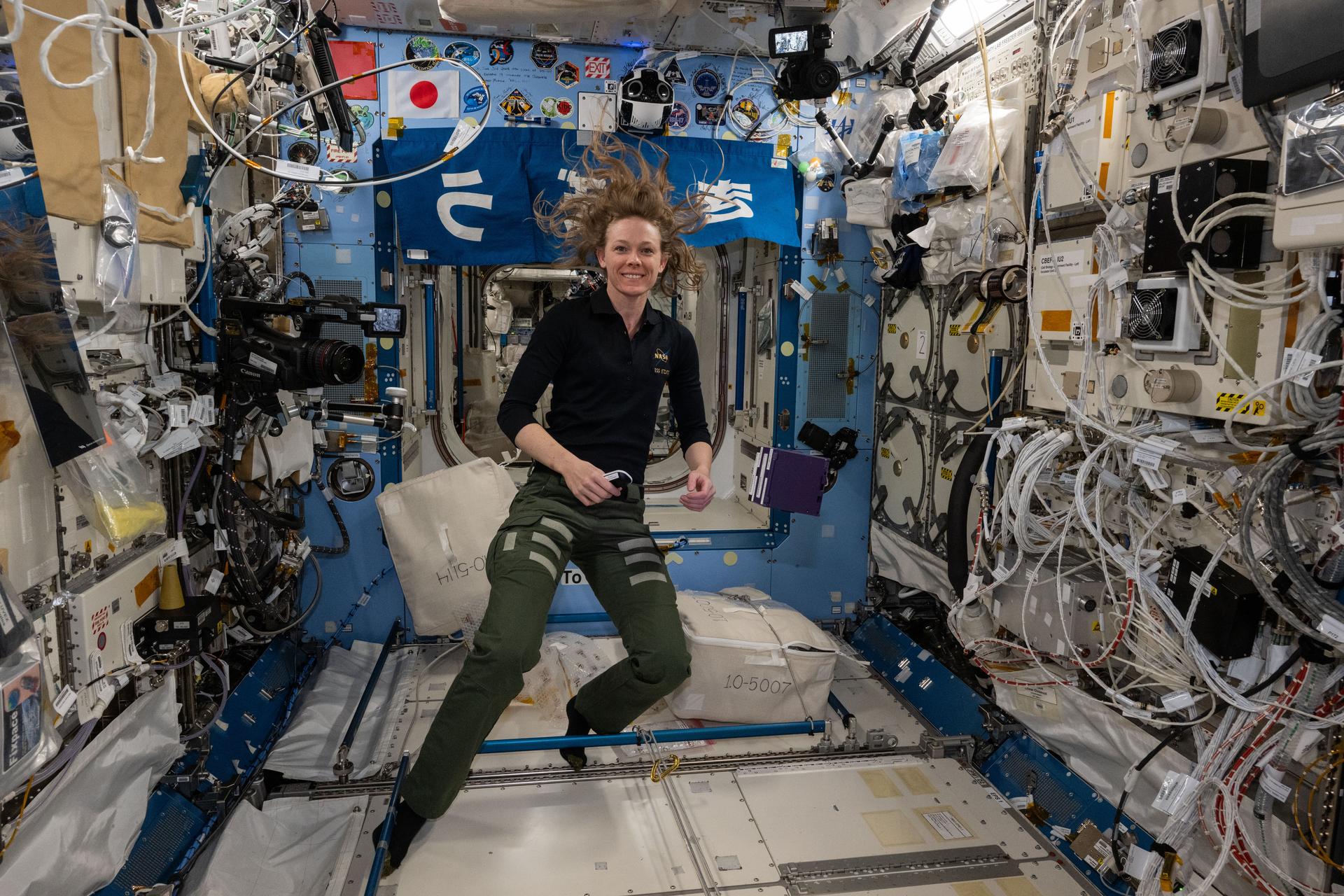 NASA astronaut and Expedition 73 Flight Engineer Nichole Ayers smiles for a portrait during scientific operations inside the Intenational Space Station's Kibo laboratory module.
