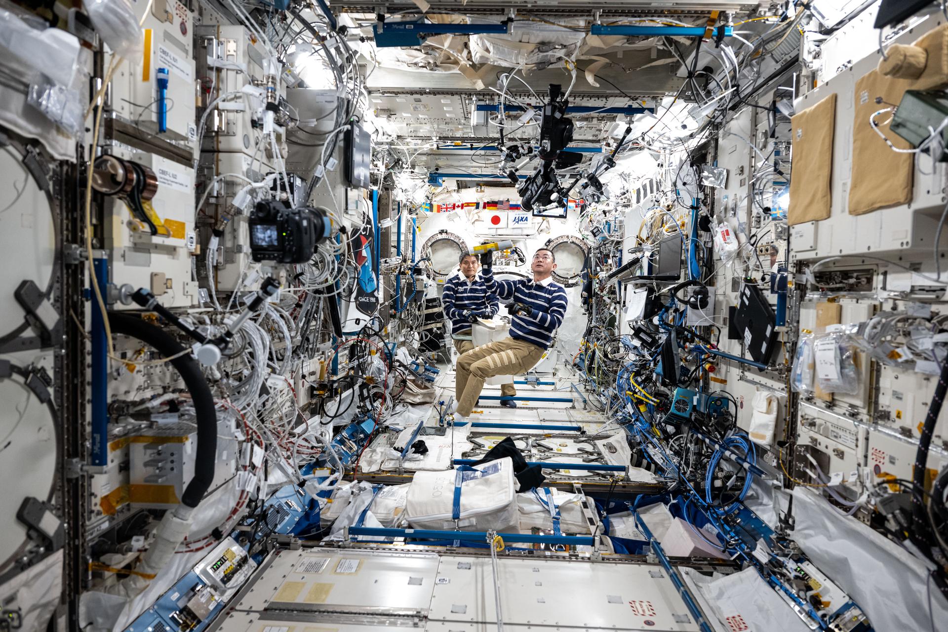 From left, JAXA (Japan Aerospace Exploration Agency) astronauts Takuya Onishi and Kimiya Yui, Expedition 73 Commander and Flight Engineer respectively, are pictured during crew familiarization activities inside the International Space Station's Kibo laboratory module.