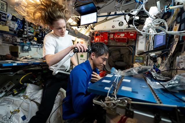 NASA image: Nichole Ayers trims Takuya Onishi's hair aboard the International Space Station