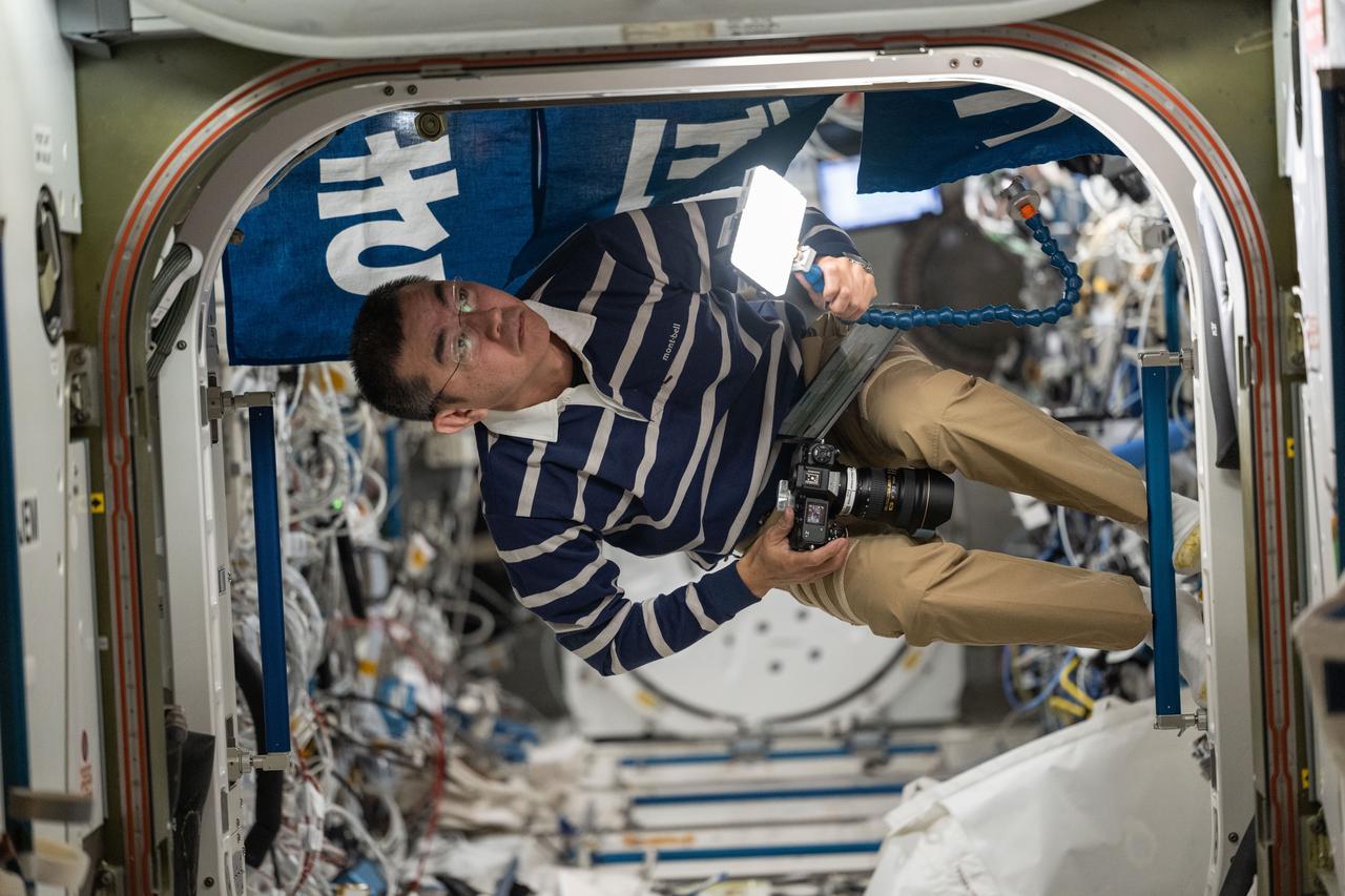 iss073e0424048 (Aug. 7, 2025) --- JAXA (Japan Aerospace Exploration Agency) astronaut and Expedition 73 Flight Engineer Kimiya Yui is pictured inside the vestibule inspecting hardware between Kibo laboratory module and the Harmony module aboard the International Space Station.