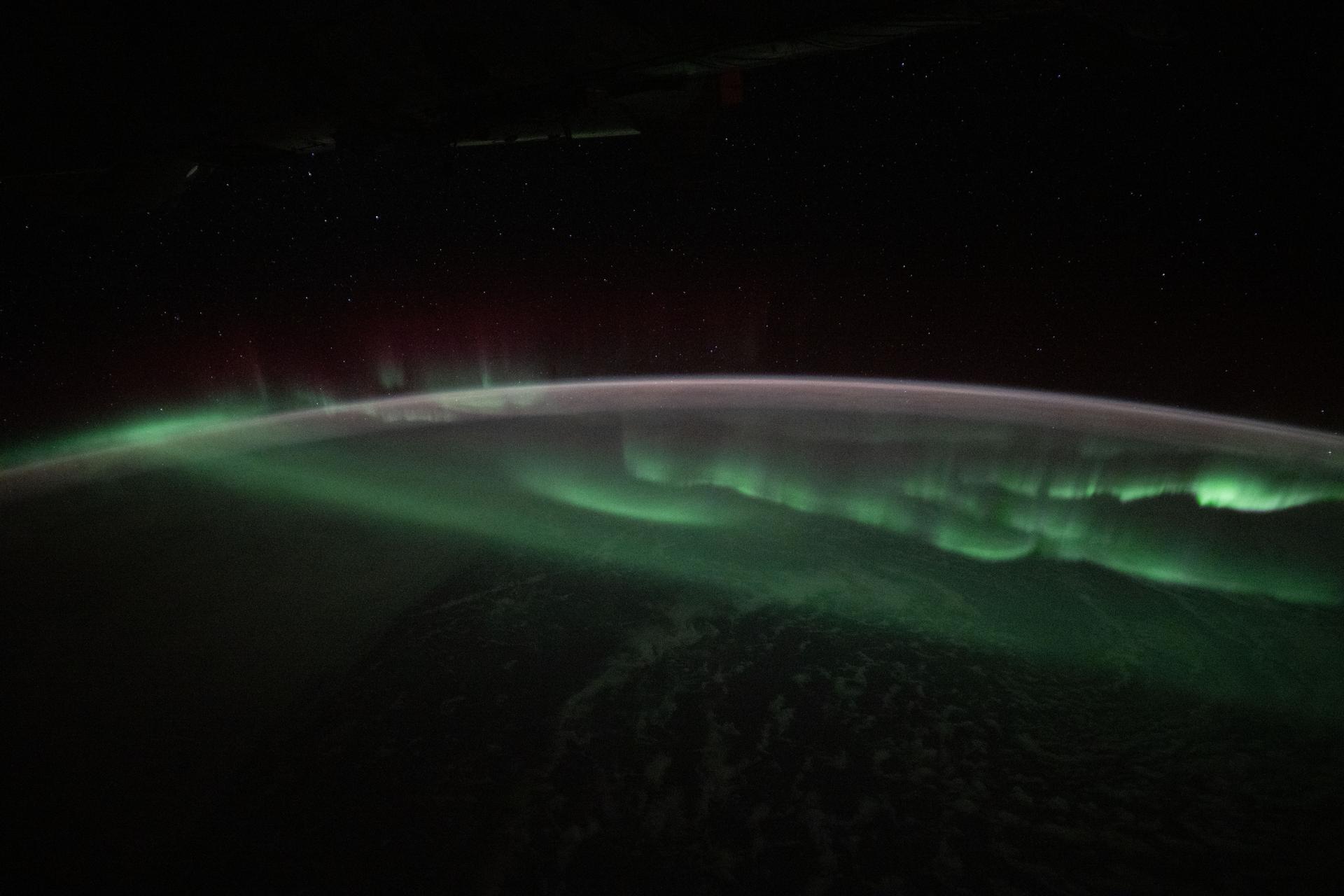 The aurora australis appears to lap over the Earth like a tide washing ashore in this photograph taken at approximately 3:45 a.m. local time from the International Space Station as it orbited 269 miles above the Indian Ocean southwest of Australia.
