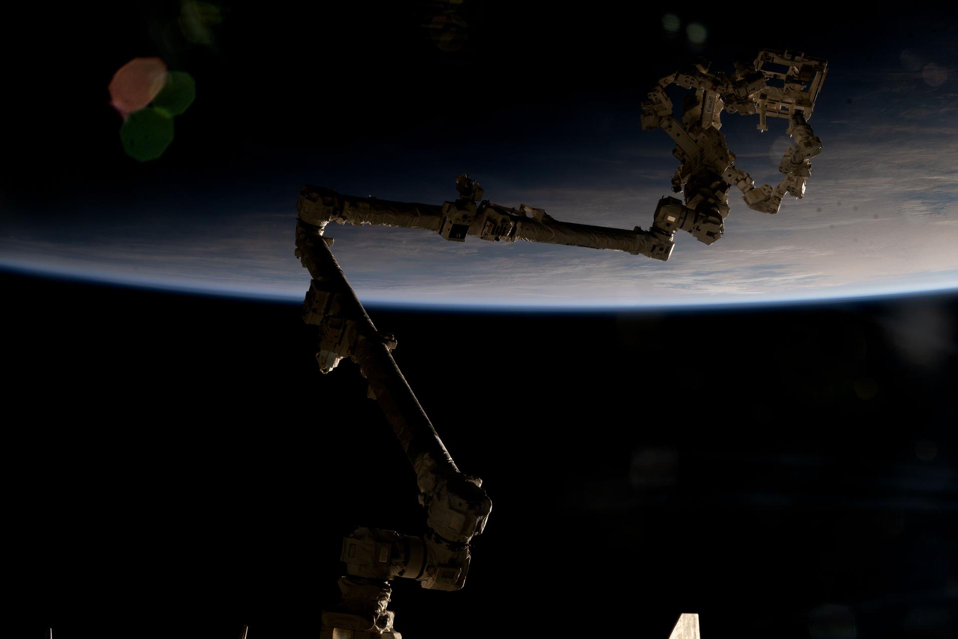 The International Space Station's 57.7-foot-long robotic arm, also known as the Canadarm2, is partially silhouetted against an orbital sunrise 271 miles above the Indian Ocean south of Australia's island state of Tasmania. Attached to the Canadarm2's latching end effector is Dextre (top right), the fine-tuned robotic hand that performs precise maintenance capabilities on the orbital outpost, including removing and replacing small parts and performing photographic inspections, reducing the need for time-intensive spacewalks.