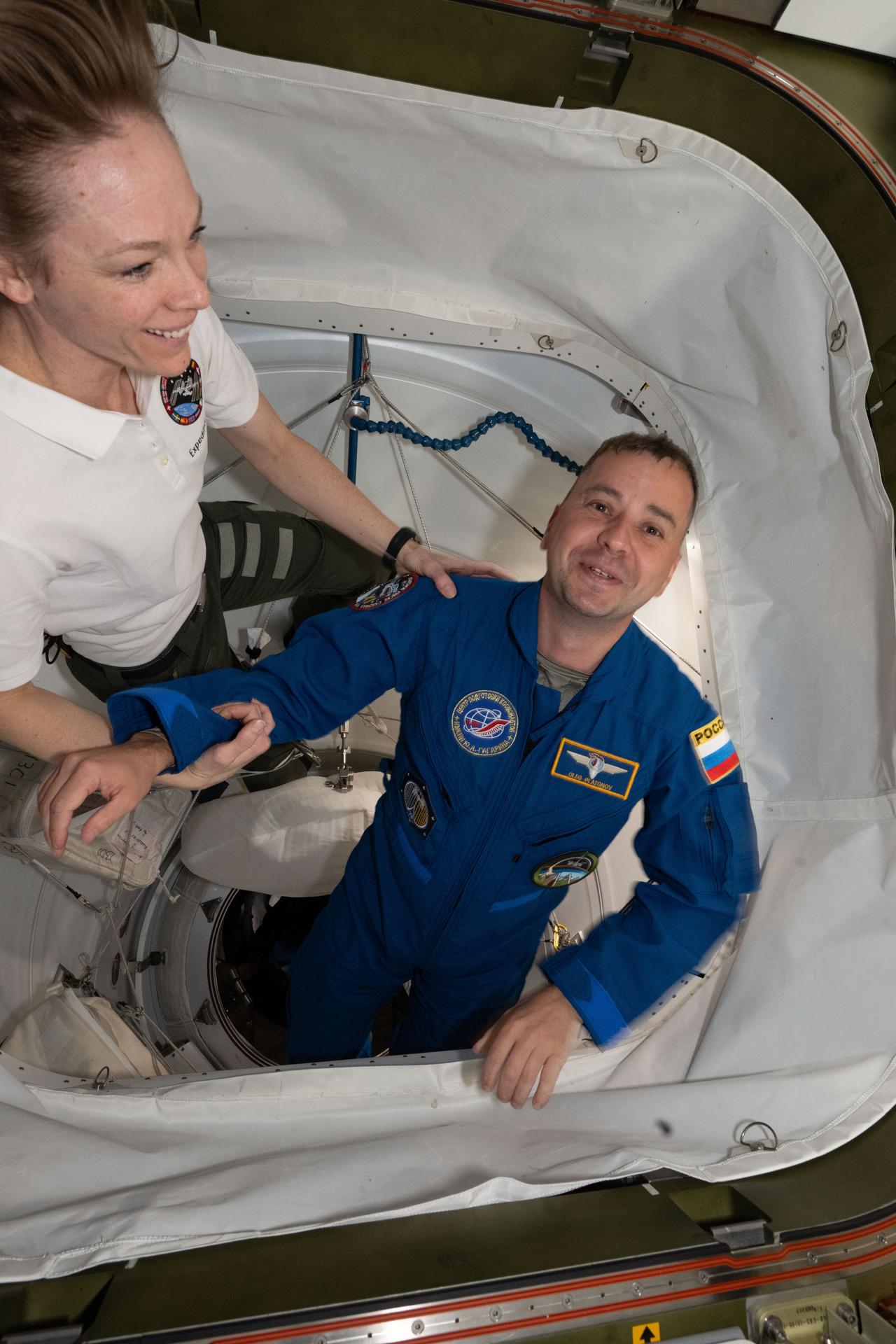 NASA's SpaceX Crew-11 Mission Specialist Oleg Platonov of Roscosmos is welcomed aboard the International Space Station by Expedition 73 Flight Engineer Nichole Ayers of NASA after the Dragon crew spaceraft docked to the Harmony module's space-facing port.