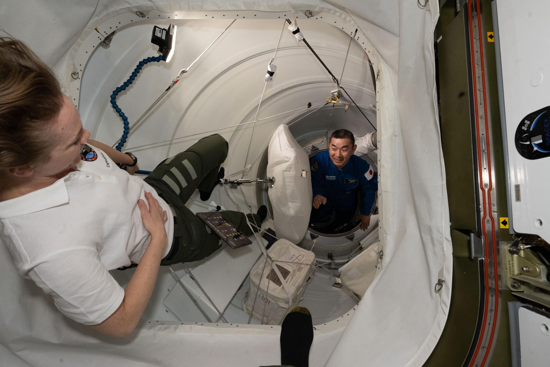NASA's SpaceX Crew-11 Mission Specialist Kimiya Yui of JAXA (Japan Aerospace Exploration Agency) is welcomed aboard the International Space Station by Expedition 73 Flight Engineer Nichole Ayers of NASA after the Dragon crew spaceraft docked to the Harmony module's space-facing port.