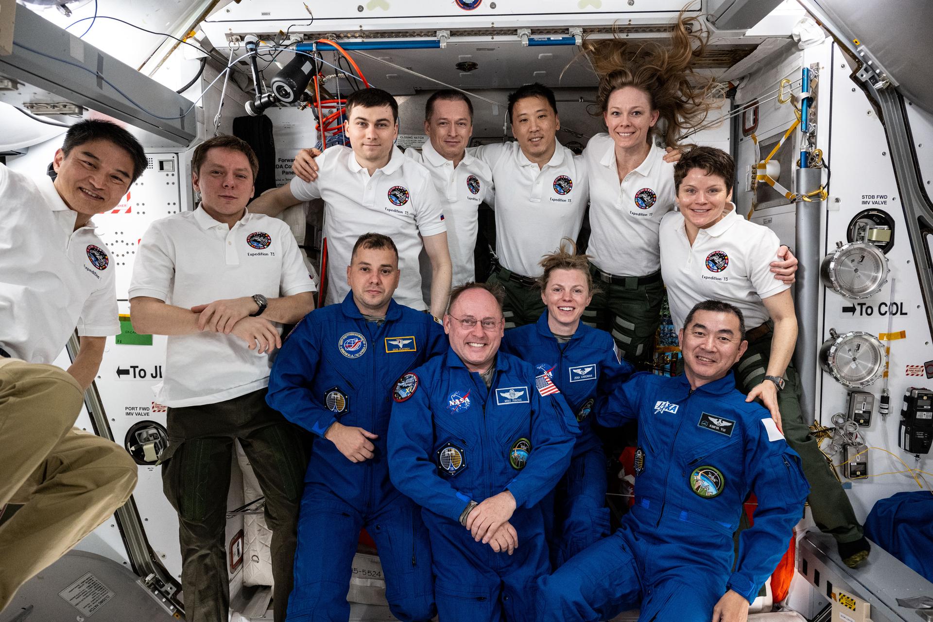 Expedition 73 poses for a portrait after welcoming four new crew members shortly after they arrived on a SpaceX Dragon crew spacecraft as part of NASA's SpaceX Crew-11 mission. In the front row from left, are the newest crewmates Roscosmos cosmonaut Oleg Platonov, NASA astronauts Mike Fincke and Zena Cardman, and JAXA (Japan Aerospace Exploration Agency) astronaut Kimiya Yui. In the back row, are JAXA astronaut Takuya Onishi, Roscosmos cosmonauts Kirill Peskov, Alexey Zubritsky, and Sergey Ryzhikov, and NASA astronauts Jonny Kim, Nichole Ayers, and Anne McClain.
