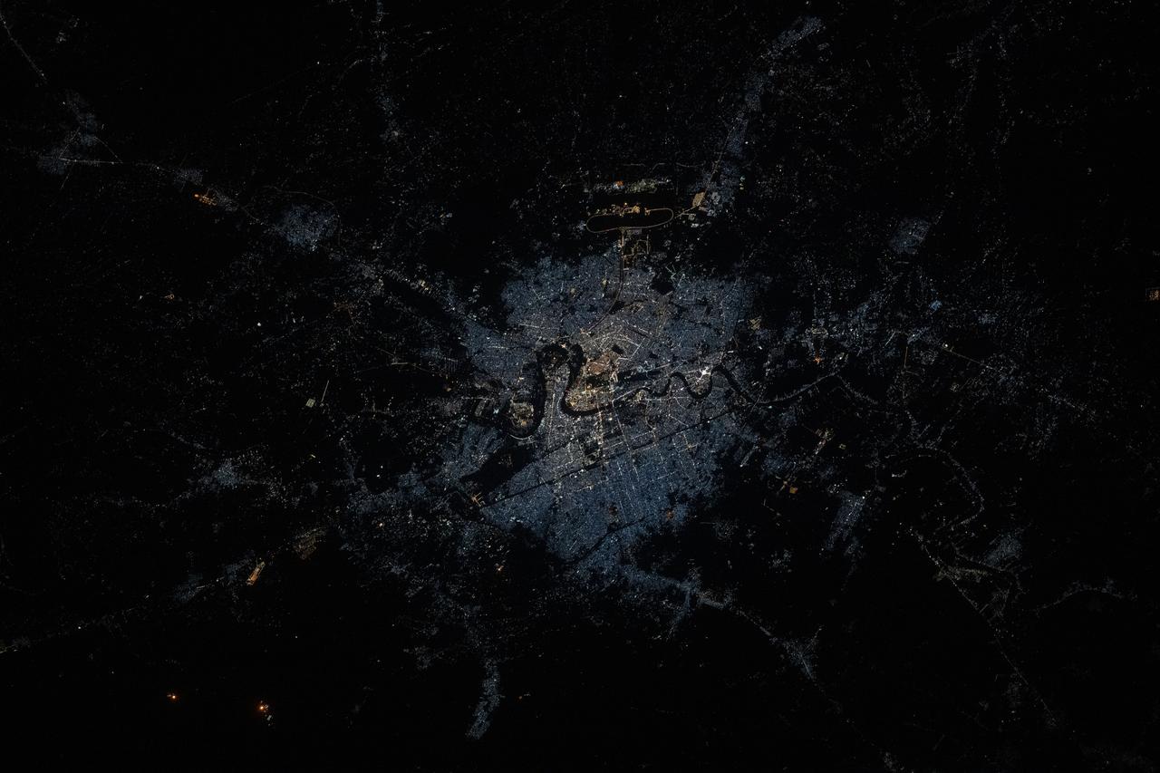 iss073e0515117 (Aug. 23, 2025) --- Baghdad, Iraq, split by the Tigris River and with a population of about 7.92 million, is pictured at approximately 1:58 a.m. local time from the International Space Station as it orbited 261 miles above. The dark, oval area toward the top is Baghdad International Airport hosting both civilian airlines and military aircraft. Credit: JAXA (Japan Aerospace Exploration Agency)