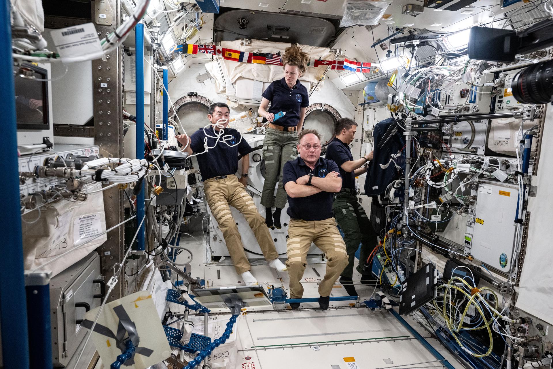 Expedition 73 Flight Engineers (clockwise from top) Zena Cardman, Jonny Kim, and Mike Fincke, all three NASA astronauts, and Kimita Yui from JAXA (Japan Aerospace Exploration Agency) gather together inside the Kibo laboratory module prior to a conference with officials on the ground.