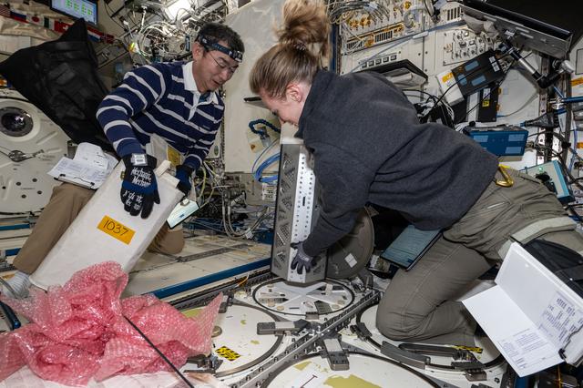 NASA image: Astronauts Kimiya Yui and Zena Cardman unpack science, supplies, and hardware
