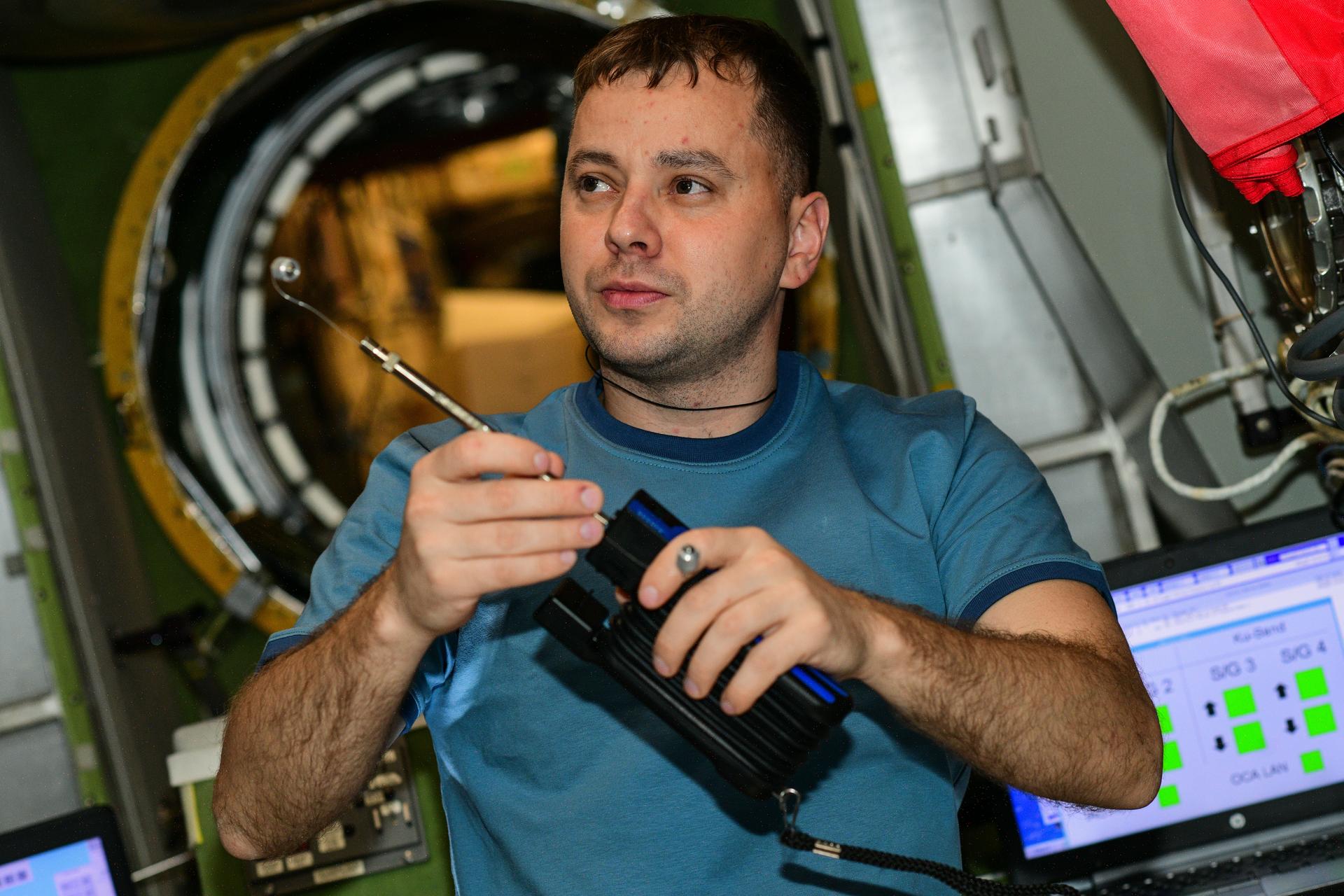 Roscosmos cosmonaut and Expedition 73 Flight Engineer Oleg Platonov is pictured with an air sampling device to detect and analyze trace contaminants such as carbon dioxide and ammonia to ensure a safe breathable environment aboard the International Space Station.