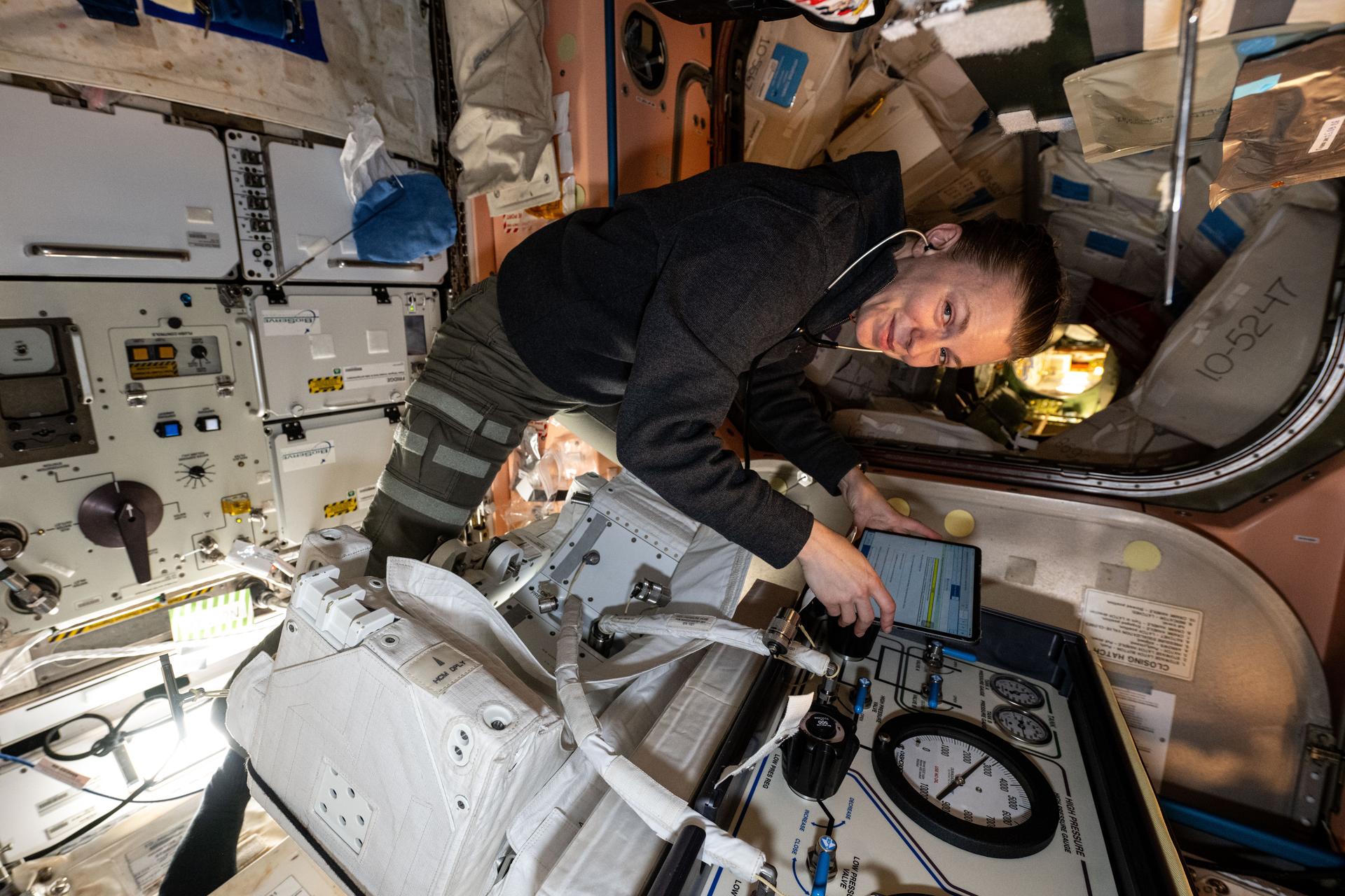 NASA astronaut and Expedition 73 Flight Engineer Zena Cardman works inside the International Space Station's Quest airlock and performs pressure and leak checks on spacesuit jetpack components. The jetpacks are attached to the rear of spacesuits and are a safety mechanism a spacewalker would use to maneuver back to the orbital outpost in the unlikely event they became untethered from their worksite.
