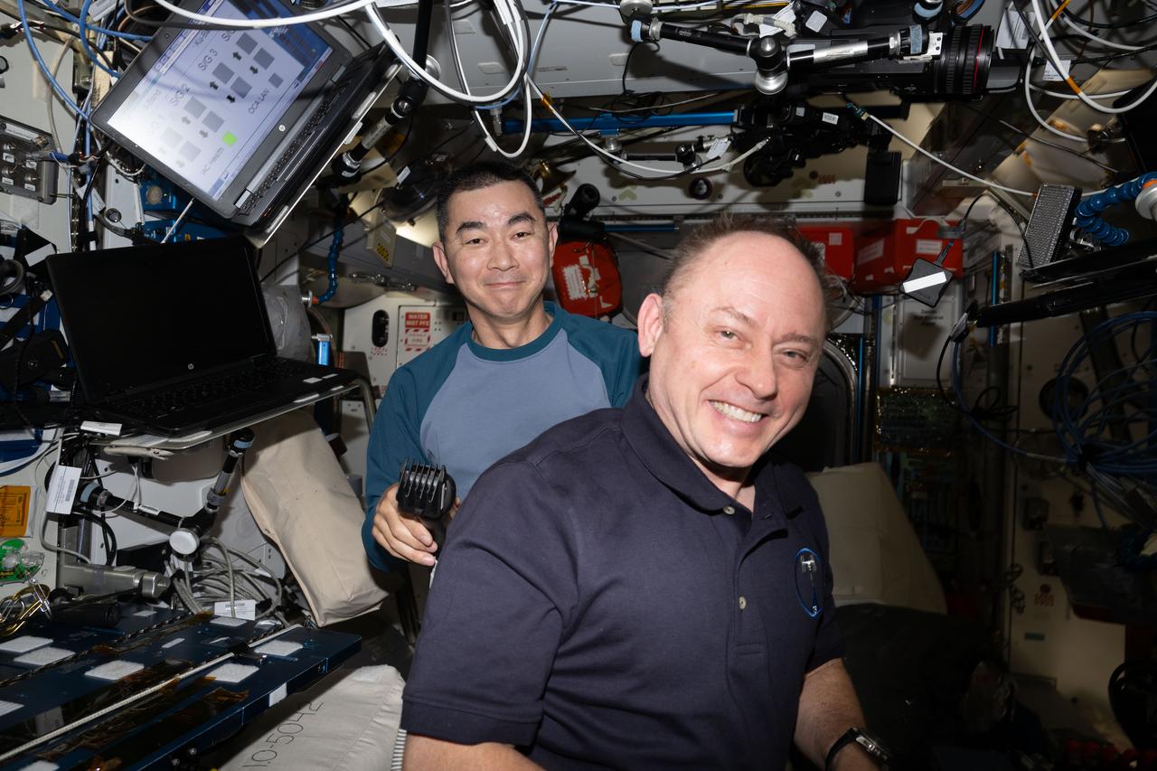 iss073e0603004 (Aug. 30, 2025) --- JAXA (Japan Aerospace Exploration Agency) astronaut Kimiya Yui smiles for a portrait after trimming NASA astronaut Mike Fincke's hair aboard the International Space Station.