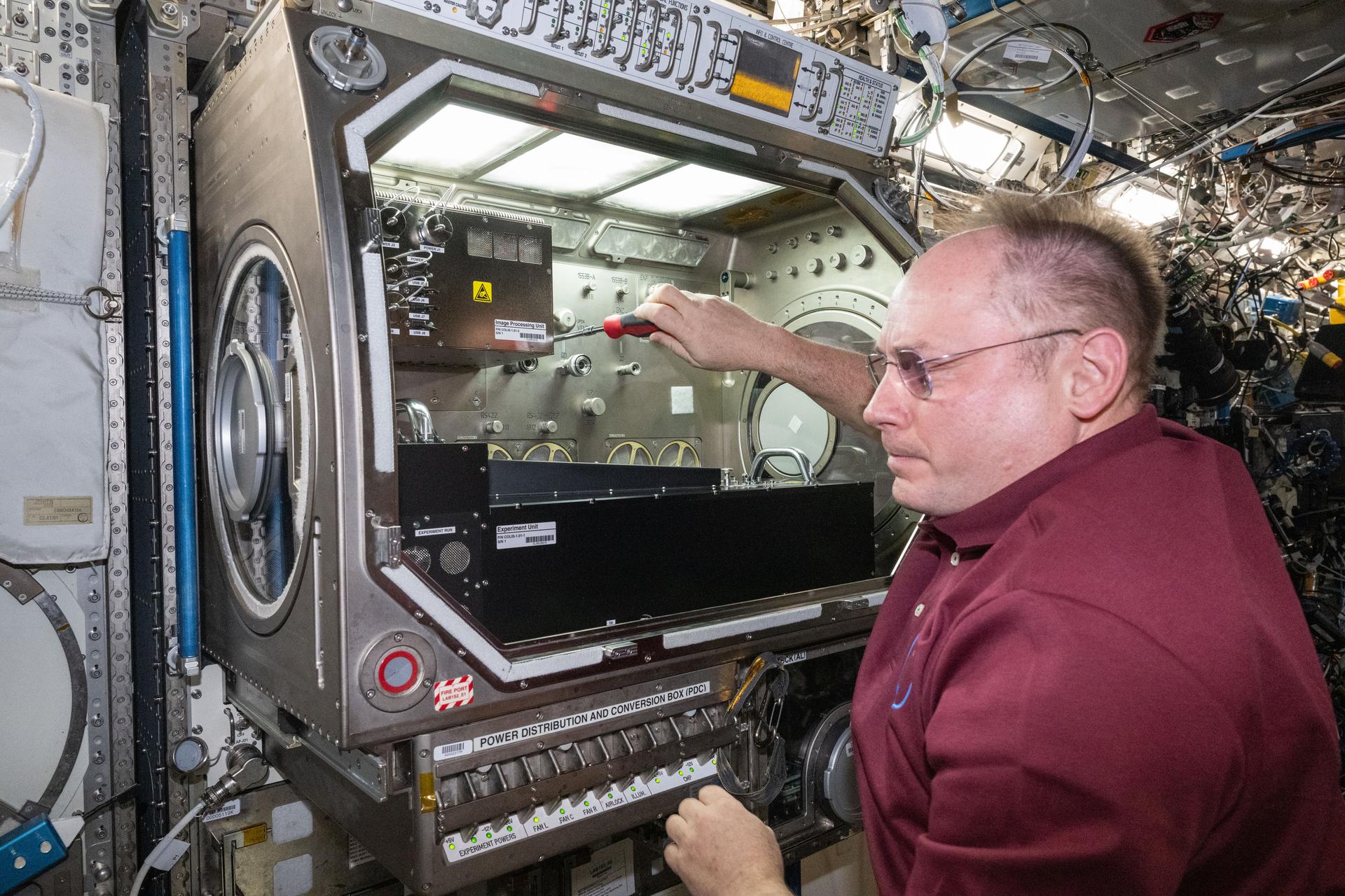 NASA astronaut and Expedition 73 Flight Engineer Mike Fincke sets up the Colloidal Solids research hardware inside the Destiny laboratory module’s Microgravity Science Glovebox aboard the International Space Station. The physics study is investigating pharmaceutical manufacturing and 3D printing techniques in space potentially advancing human health on and off the Earth.