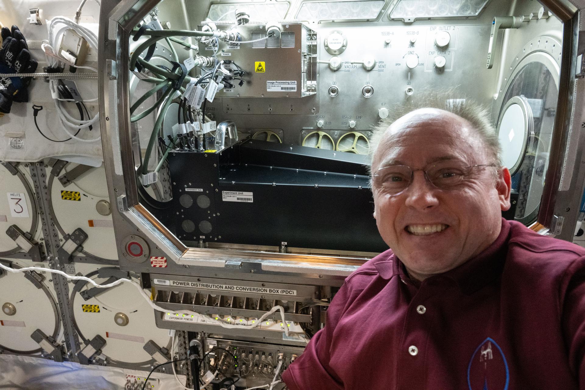 NASA astronaut and Expedition 73 Flight Engineer Mike Fincke poses for a portrait in front of the Microgravity Science Glovebox (MSG) inside the International Space Station’s Destiny laboratory. Fincke installed the Colloidal Solids research hardware in the MSG to explore pharmaceutical manufacturing and 3D printing techniques in microgravity—research that could advance human health both in space and on Earth.