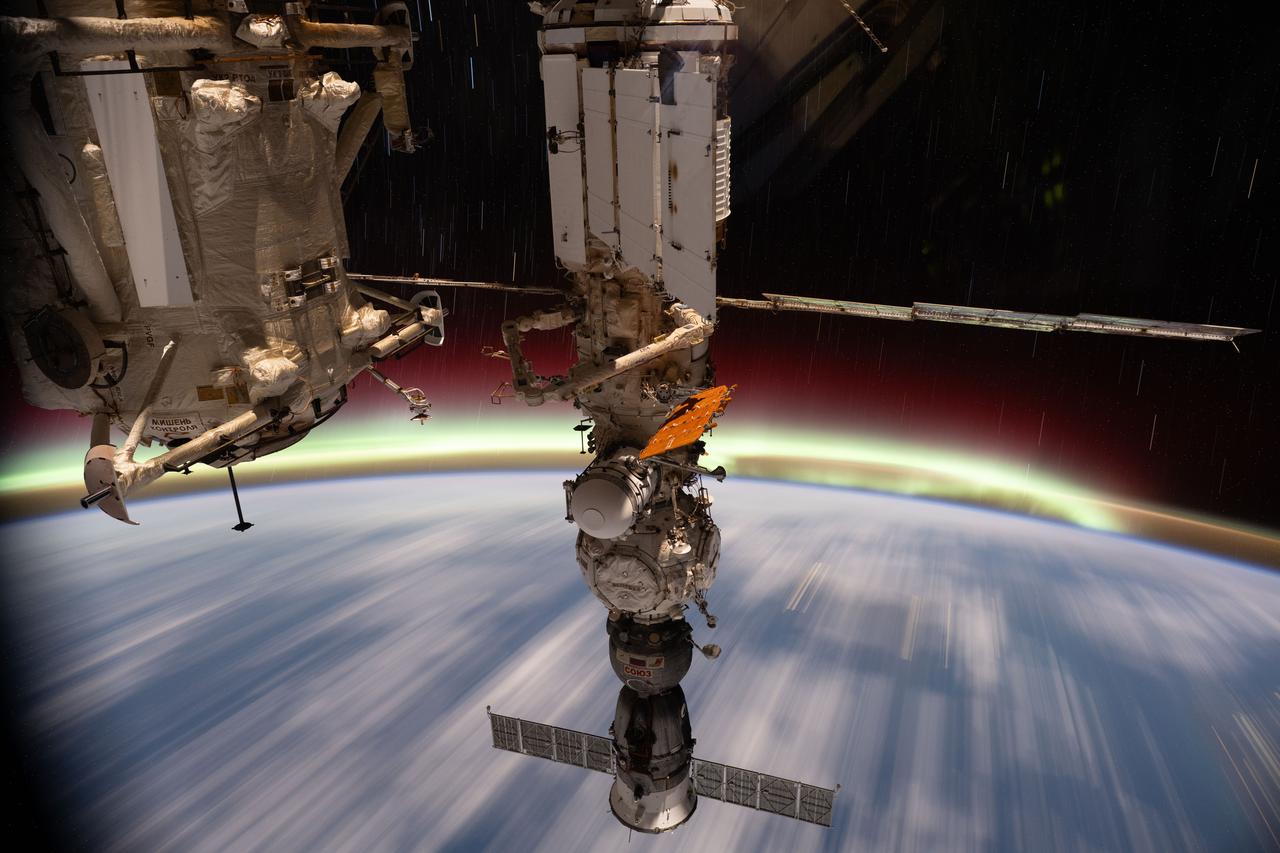 iss073e0608785 (June 13, 2025) --- The aurora australis streams above Earth's horizon in this long duration photograph taken from the International Space Station as it orbited 266 miles above the Tasman Sea off the coast of Sydney, Australia, at approximately 3:28 a.m. local time. Portions of the orbital outpost's Roscosmos segment are visible in the foreground, including (from left) the Rassvet module and the Soyuz MS-27 crew spacecraft docked to the Prichal module which is itself attached to the Nauka science module.