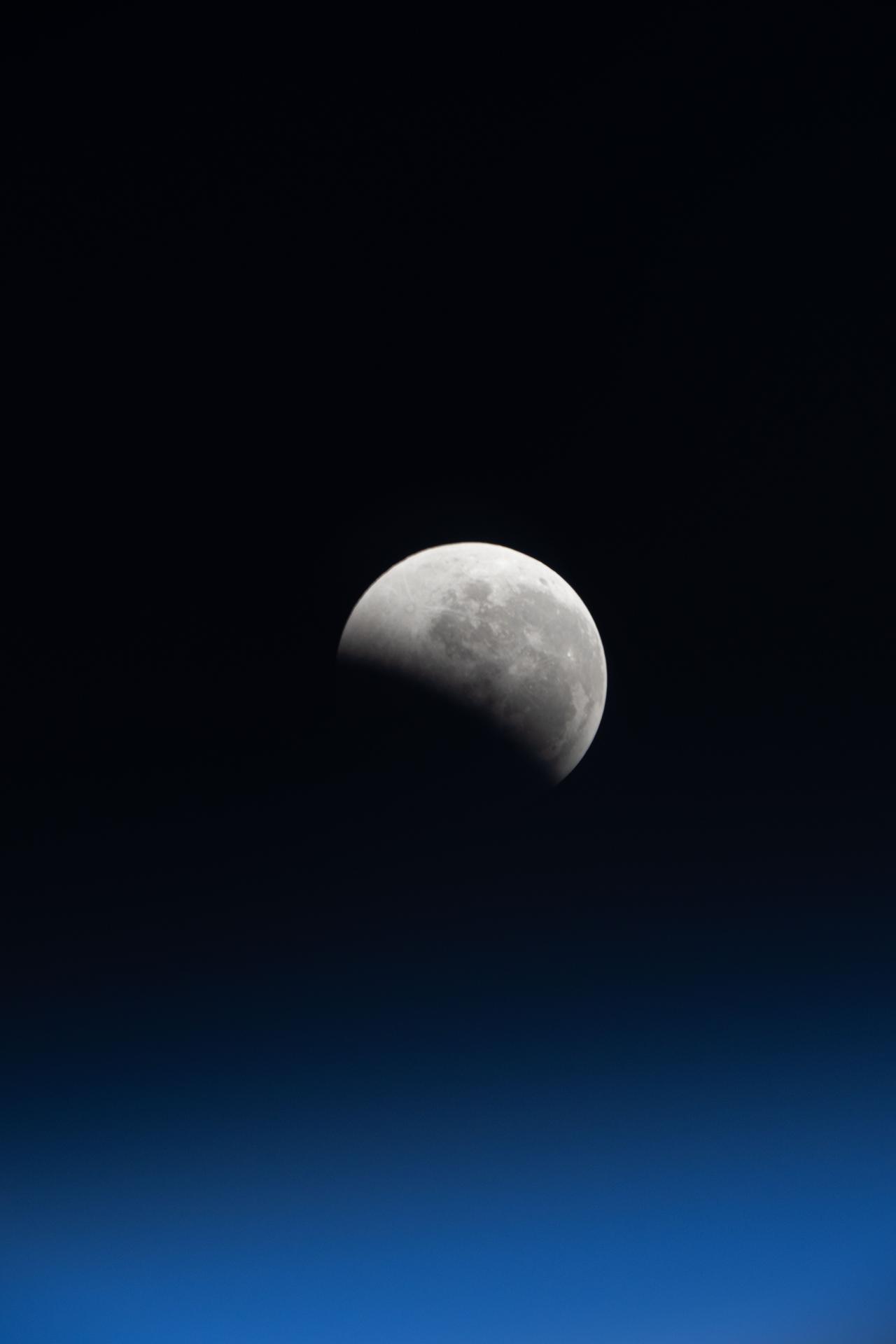 The lunar eclipse, also known as the Blood Moon, is pictured just above Earth's horizon from the International Space Station as it orbited 266 miles above the South Pacific Ocean.