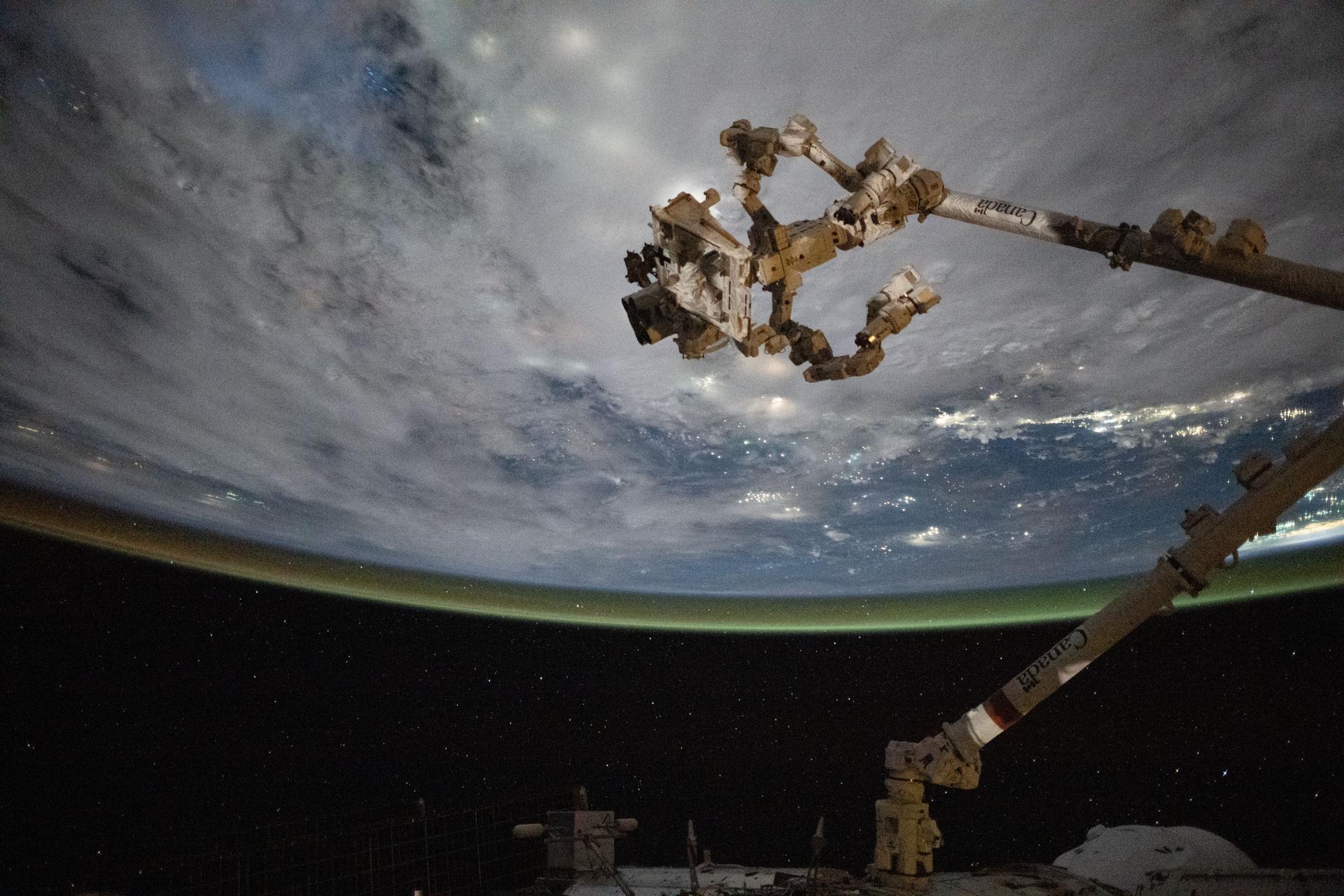 The Canadarm2 robotic arm with Dextre, its fine-tuned robotic hand attached, is pictured extending from the International Space Station as it orbited 258 miles above the coast of Cambodia on a cloudy Gulf of Thailand.