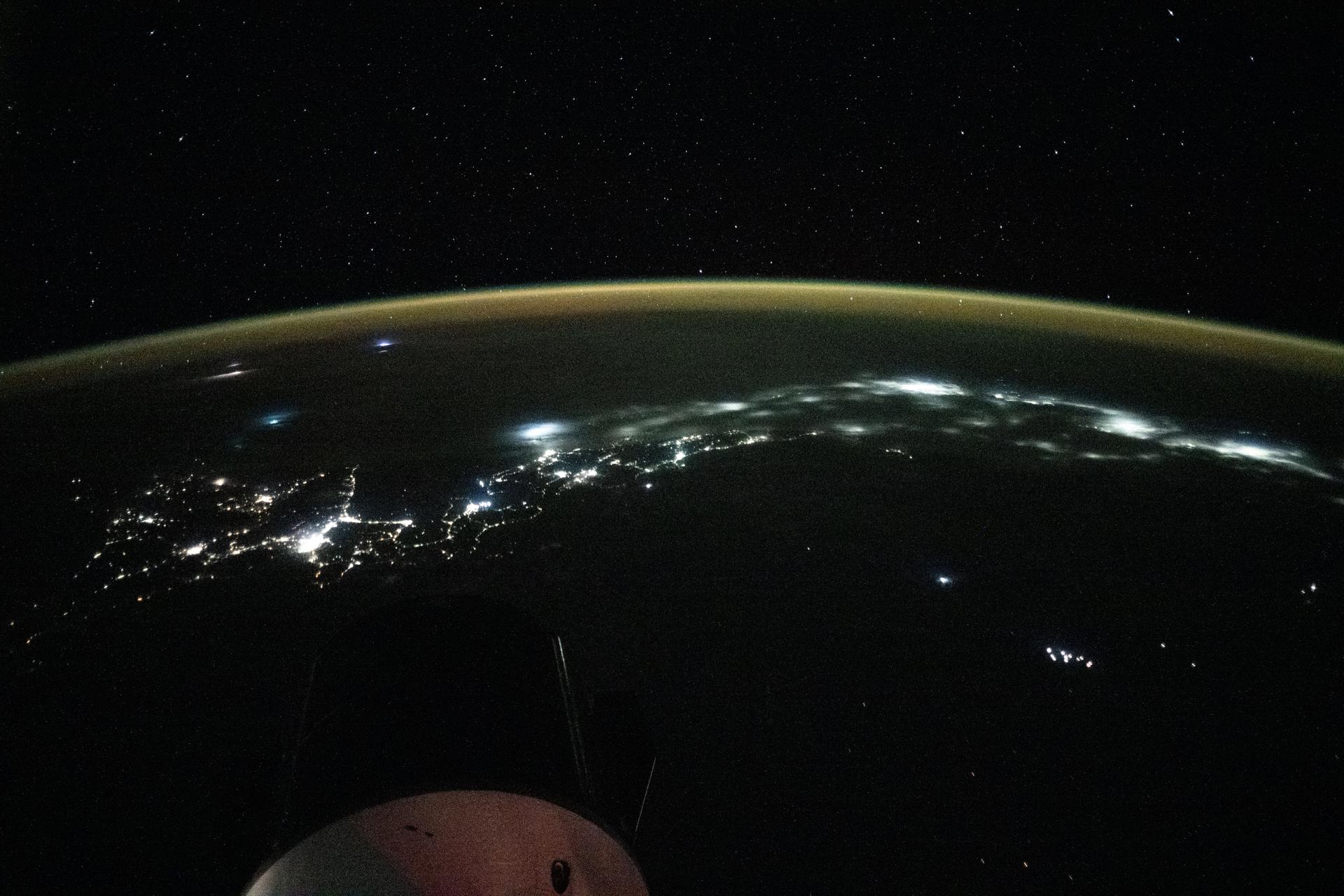 City lights trace the Japanese coastline underneath a dim yellow-green airglow in this nighttime view across the Sea of Japan, revealing the metropolitan areas (from left to right) of Sapporo, Sendai, Tokyo, and Nagoya. The International Space Station was orbiting 262 miles above Russia’s far eastern coast when this image was captured at approximately 11:29 p.m. local time.