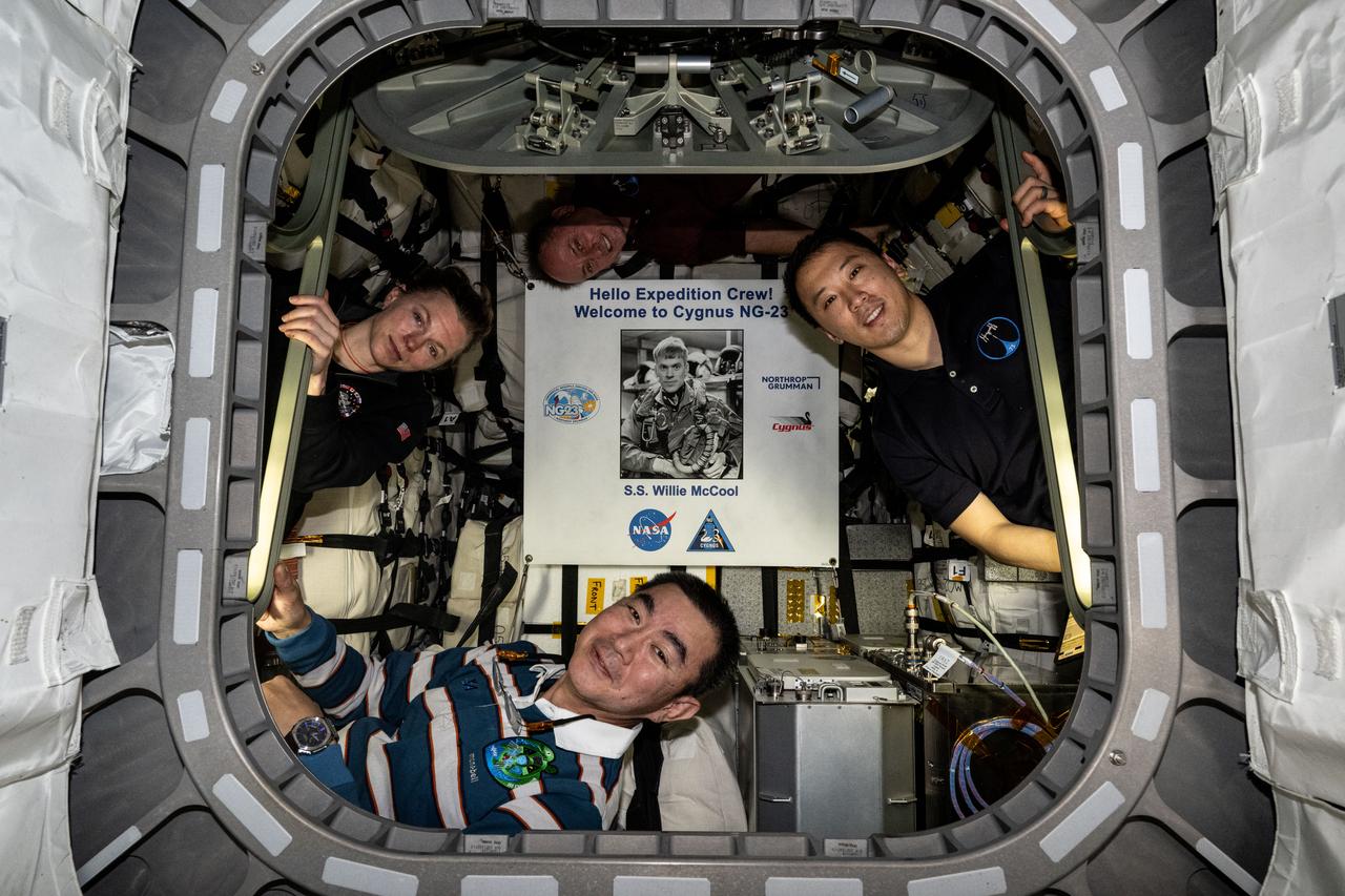 iss073e0704084 (Sept. 18, 2025) --- Pictured inside the Northrop Grumman Cygnus XL cargo craft are (clockwise from left) Flight Engineers Zena Cardman, Mike Fincke, and Jonny Kim of NASA, and Flight Engineer Kimiya Yui of JAXA (Japan Aerospace Exploration Agency). Highlighted at center, is a poster of William “Willie” McCool, in honor of the NASA astronaut who perished in 2003 during the space shuttle Columbia accident and for whom the Cygnus spacecraft is named.