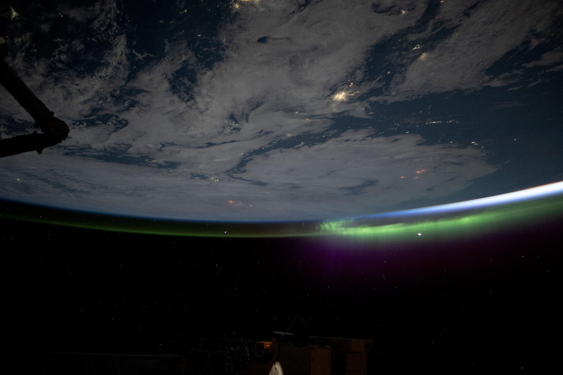 A wispy aurora caps Earth's horizon as an orbital sunrise begins illuminating the atmosphere in this photograph taken at approximately 2:19 a.m. local time from the International Space Station as it orbited 264 miles above the Mongolia-China border region.