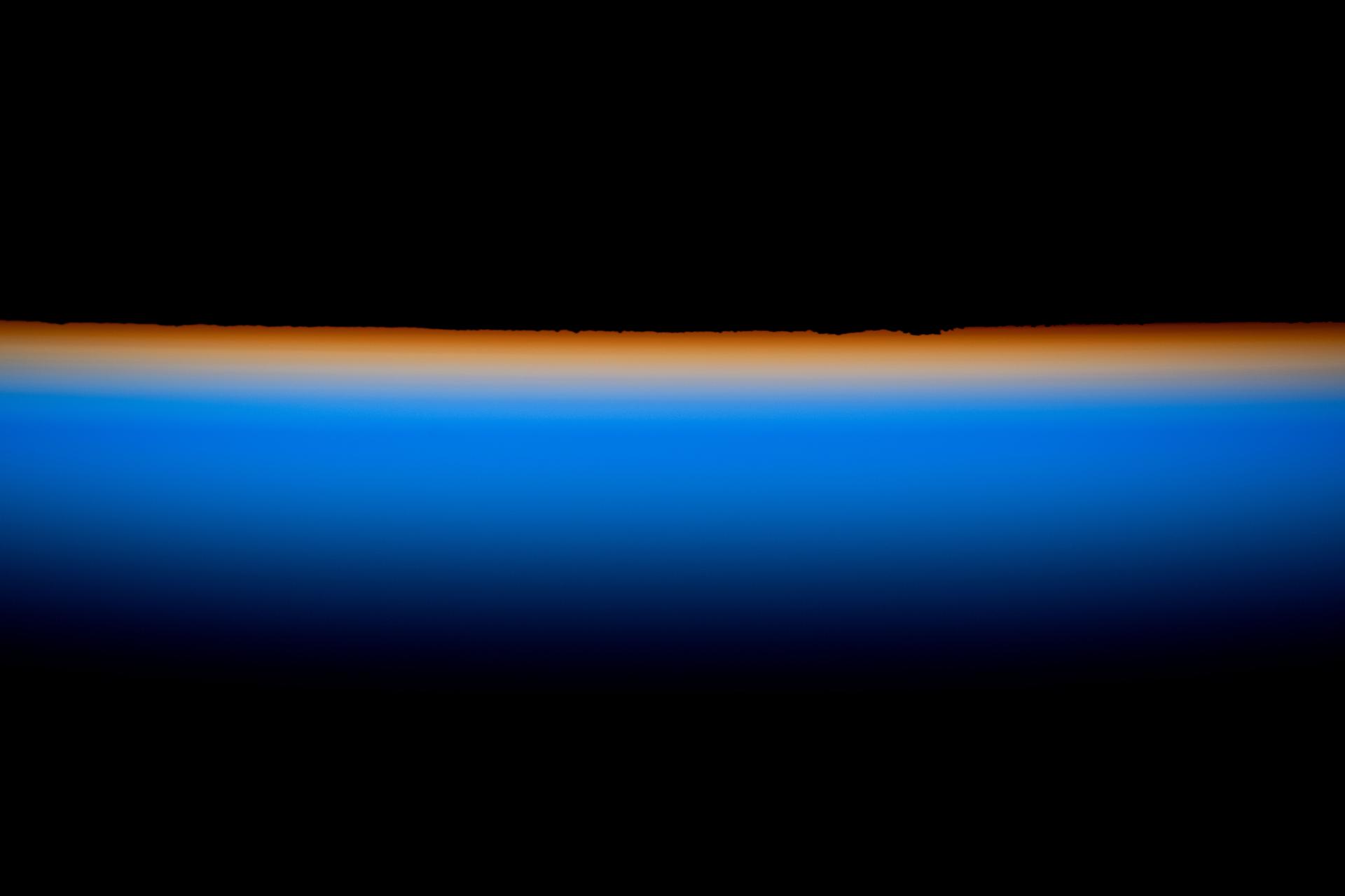 The last rays of an orbital sunset outline Earth’s horizon with a thin orange hue that fades into the blue atmosphere before dissipating into the darkness of space. The International Space Station was orbiting 262 miles above the border region between Mongolia and China at approximately 10:16 p.m. local time when this image was captured.