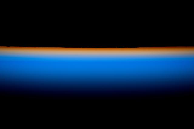 NASA image: The last rays of an orbital sunset outline Earth’s horizon with a thin orange hue