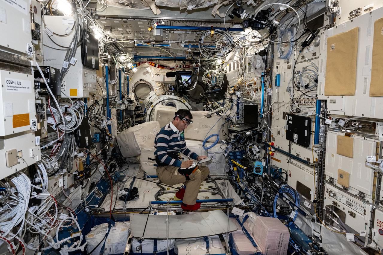 iss073e0764322 (Sept. 22, 2025) --- JAXA (Japan Aerospace Exploration Agency) astronaut and Expedition 73 Flight Engineer Kimiya Yui takes notes while installing new computer networking gear inside the Kibo laboratory module. The ethernet hub upgrades will transmit data quicker and more efficiently throughout the International Space Station.