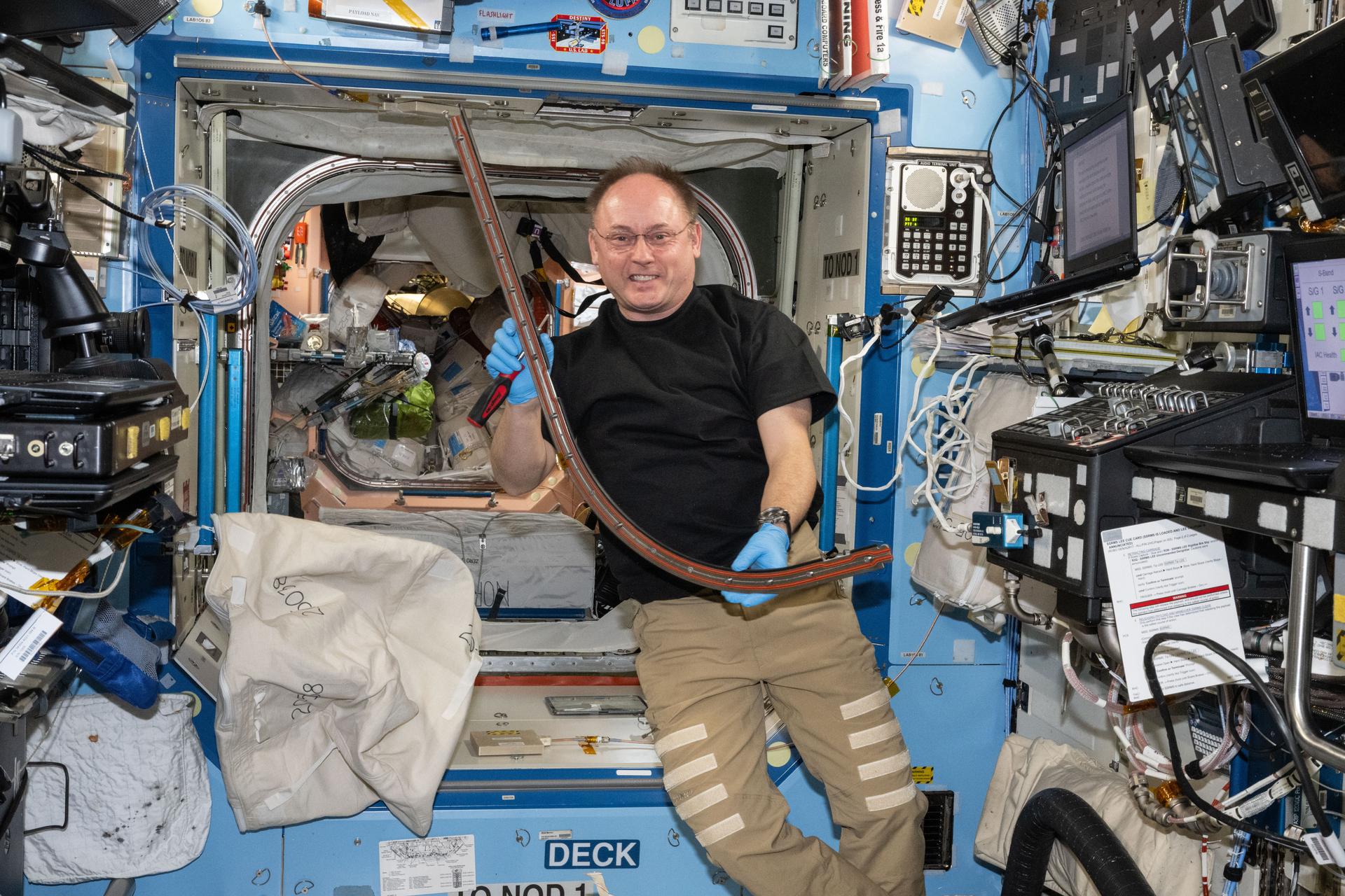 NASA astronaut and Expedition 73 Flight Engineer Mike Fincke shows off a portion of a hatch seal during maintenance work on the hatch between the Destiny laboratory module and the Harmony module aboard the International Space Station.