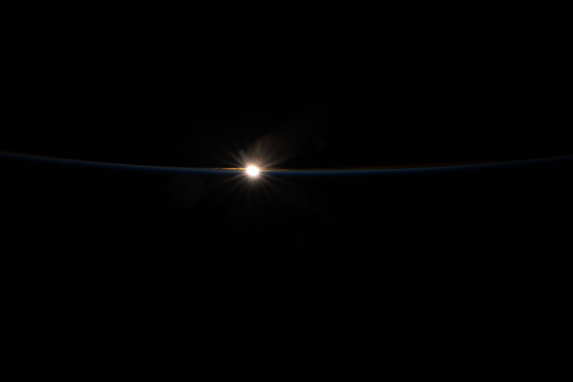 The last rays of an orbital sunset fade above Earth’s horizon, faintly illuminating the cloud tops and revealing the thin blue line of the atmosphere. The International Space Station was orbiting 262 miles above the Pacific Ocean, roughly midway between Hawaii and Alaska, at approximately 10:45 p.m. local time when this image was captured.