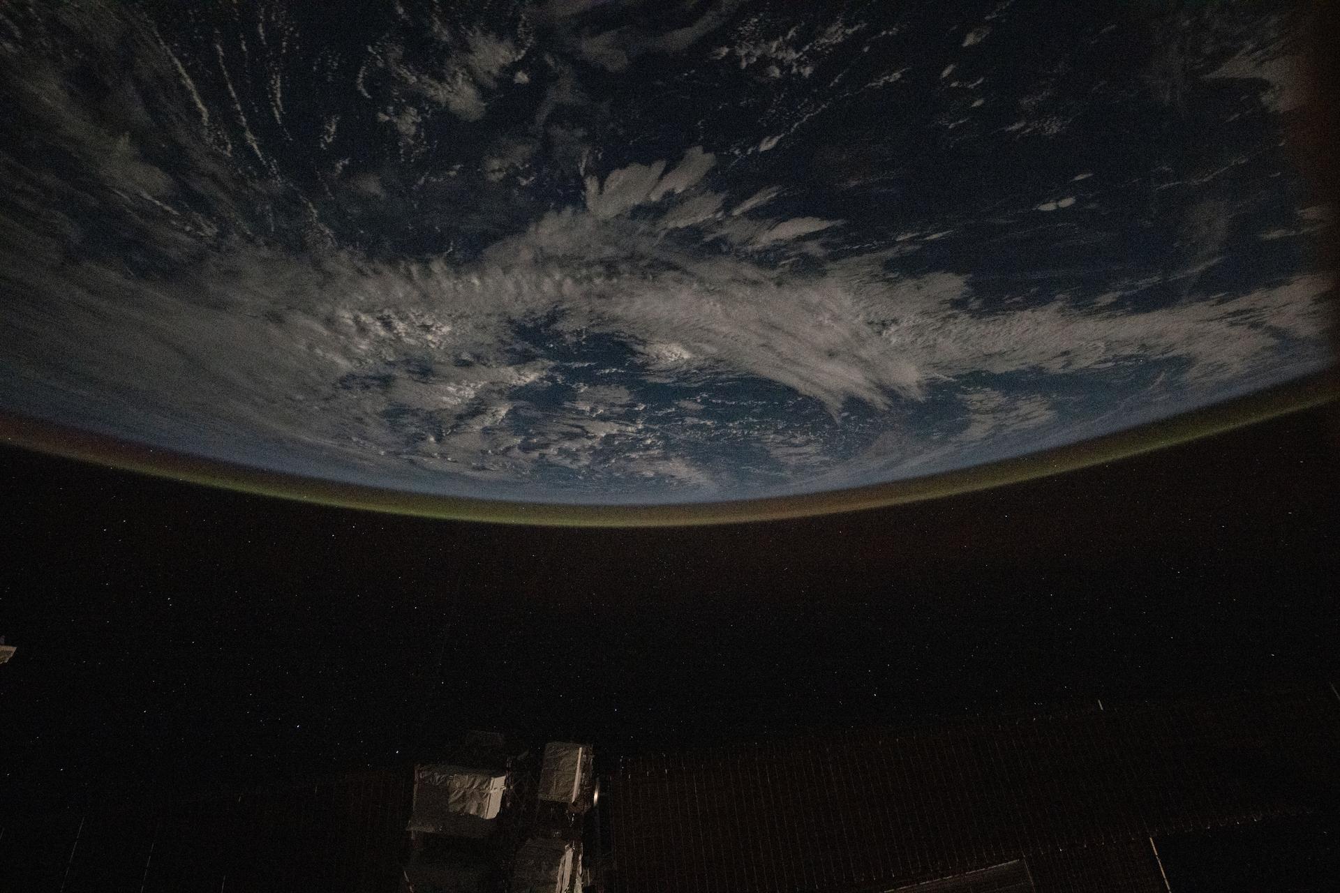 A faint airglow blankets Earth's horizon in this photograph taken from the International Space Station as it orbited 259 miles above the Pacific Ocean between Hawaii and California. This natural glow is produced when solar ultraviolet radiation excites oxygen molecules in the upper atmosphere during the day, which then release that energy as visible light at night.