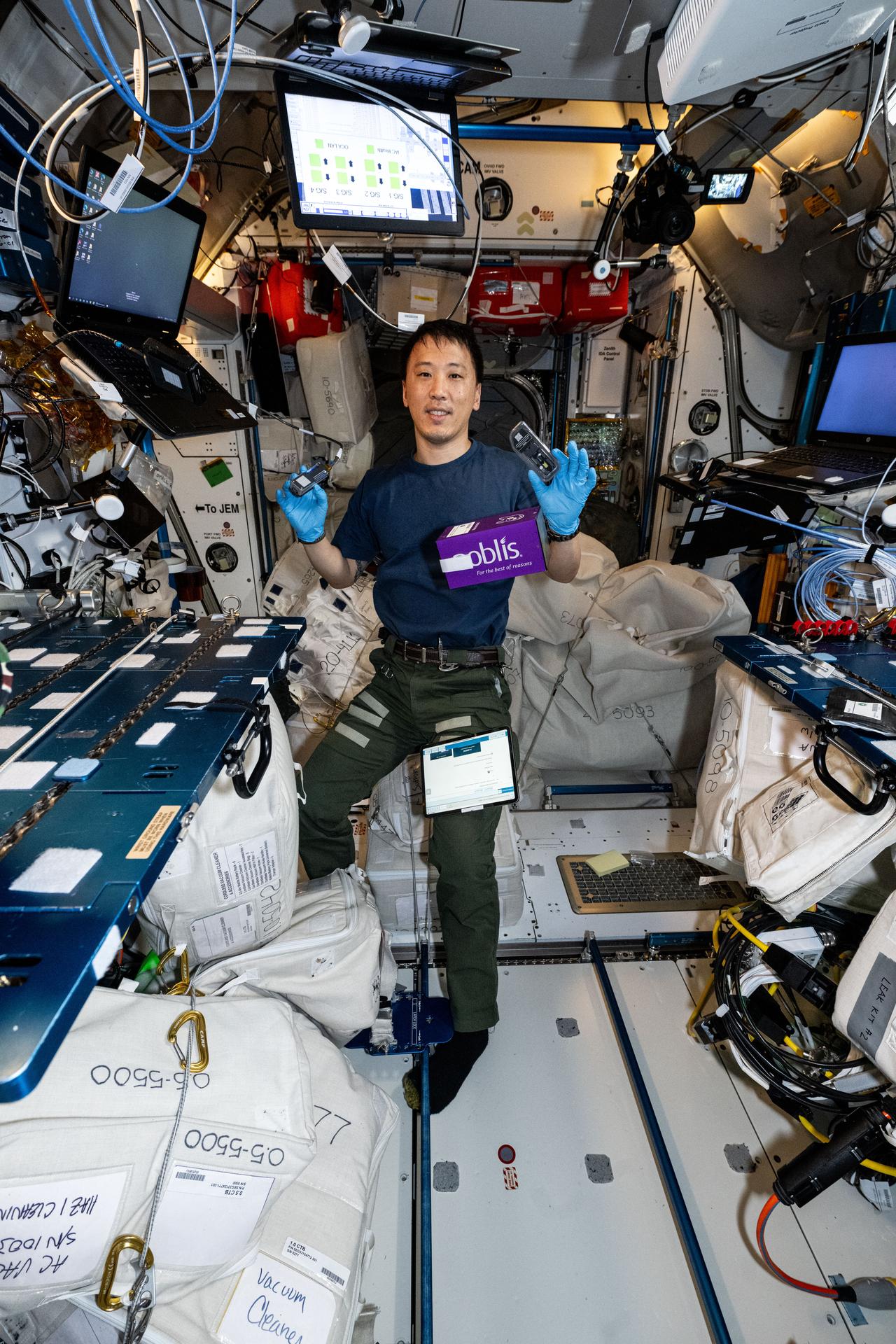 NASA astronaut and Expedition 73 Flight Engineer Jonny Kim shows off research hardware from the Voyager DNA Decryption experiment taking place inside the International Space Station's Harmony module. The biotechnology investigation explores the use of DNA as a medium for storing and encrypting digital data, aiming to reduce reliance on traditional, heavier storage systems in space.