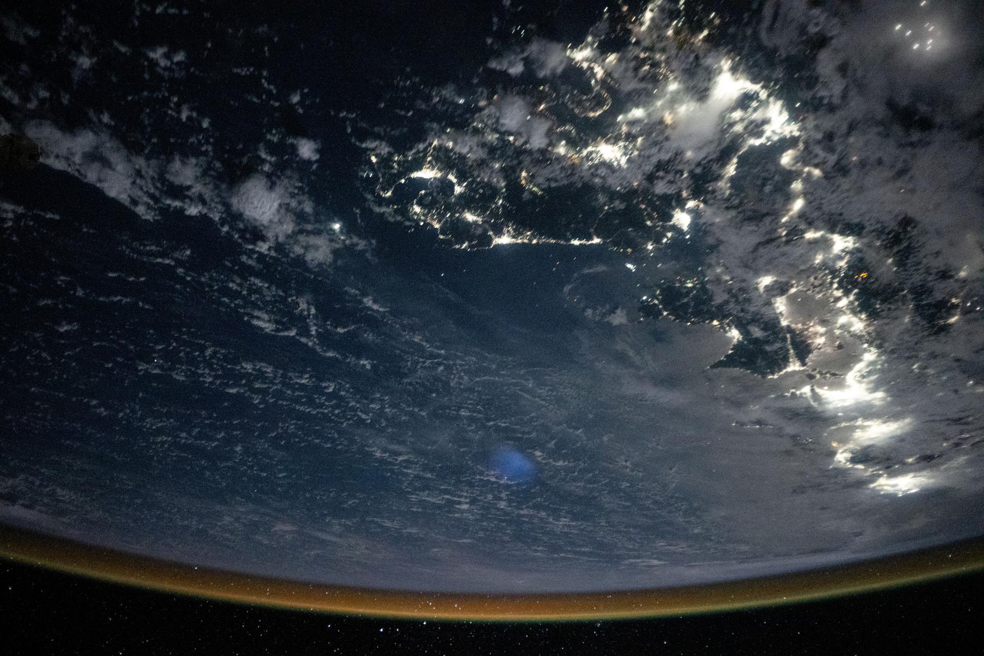 In this oblique view from the International Space Station, city lights outline southern Japan from Fukuoka (top right) to Tokyo (bottom right) with a red-yellow airglow blanketing Earth's horizon. This natural glow is produced when solar ultraviolet radiation excites oxygen molecules in the upper atmosphere during the day, which then release that energy as visible light at night. The orbital outpost was soaring 261 miles above the East China Sea at approximately 1:45 a.m. local time when this photograph was taken.