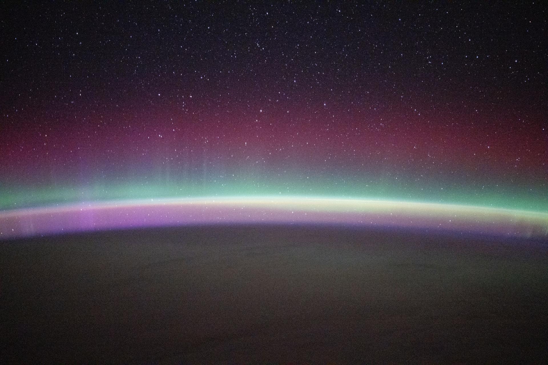 iss073e0831259 (Sept. 27, 2025) --- A green and red aurora australis shimmers beneath a starry sky and above Earth's airglow, creating a pinkish hue above the serene Indian Ocean southwest of Perth, Australia. The International Space Station was orbiting 268 miles above Earth at approximately 1:14 a.m. local time when this photograph was taken.