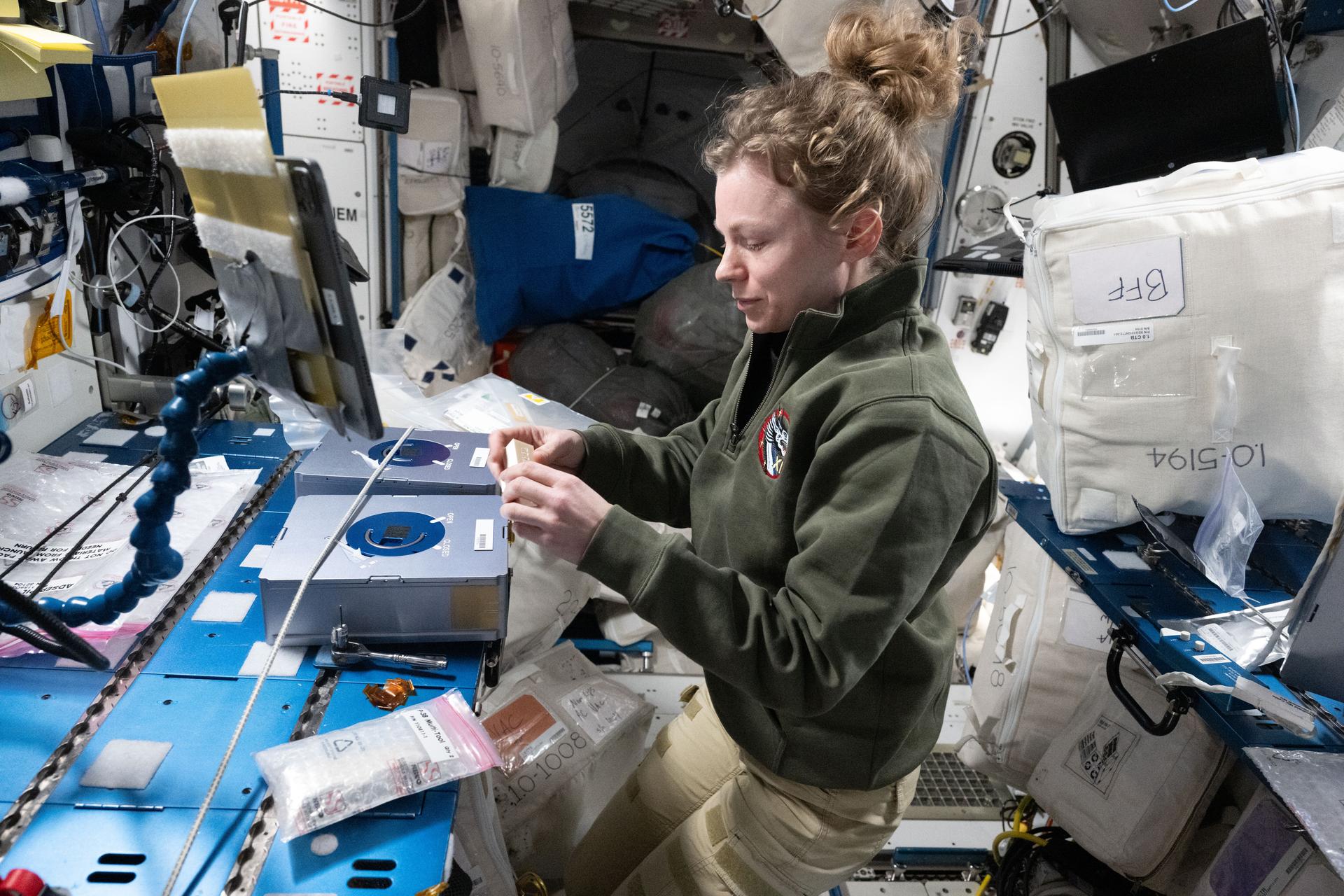 NASA astronaut and Expedition 73 Flight Engineer Zena Cardman inspects sample cassettes for installation into the Advanced Space Experiment Processor-4 (ADSEP-4) at the maintenance work area inside the International Space Station's Harmony module. She was conducting research operations for the Pharmaceutical In-space Laboratory biotechnology experiment, which is investigating methods to advance pharmaceutical manufacturing in microgravity.