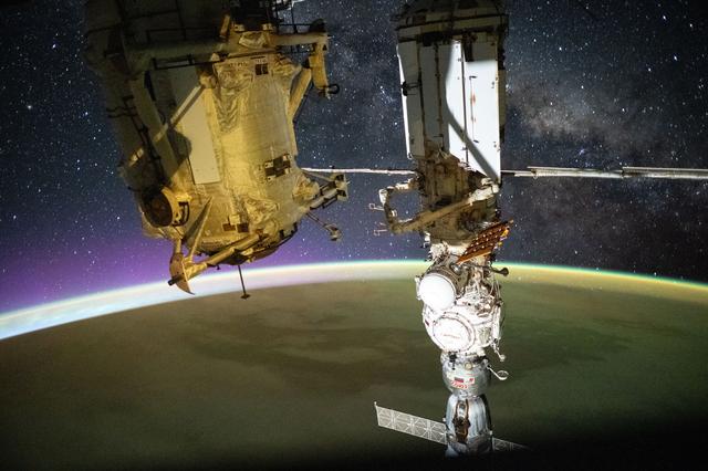 NASA image: A yellow-green airglow blankets Earth as an orbital sunrise illuminates the planet