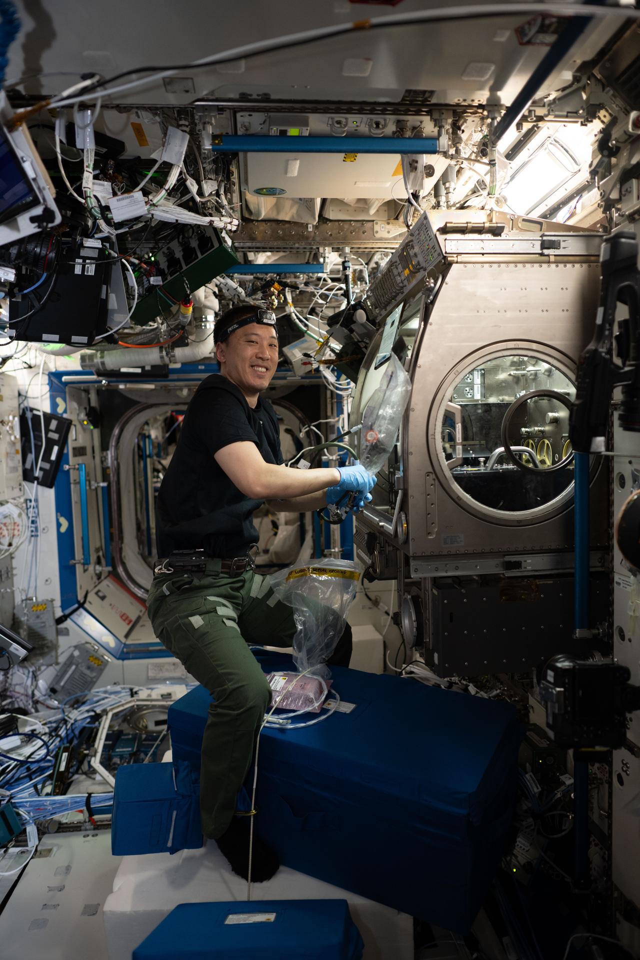 NASA astronaut and Expedition 73 Flight Engineer Jonny Kim works inside the Microgravity Science Glovebox (MSG) aboard the International Space Station’s Destiny laboratory module. Kim is seen stowing research hardware used in the Colloidal Solids physics experiment, which investigates how tiny particles—colloids—and proteins suspended in water behave in microgravity. The results may inform plant growth techniques, 3D printing technologies, and pharmaceutical manufacturing in space. On Earth, the findings could benefit the food, personal care, and healthcare industries.