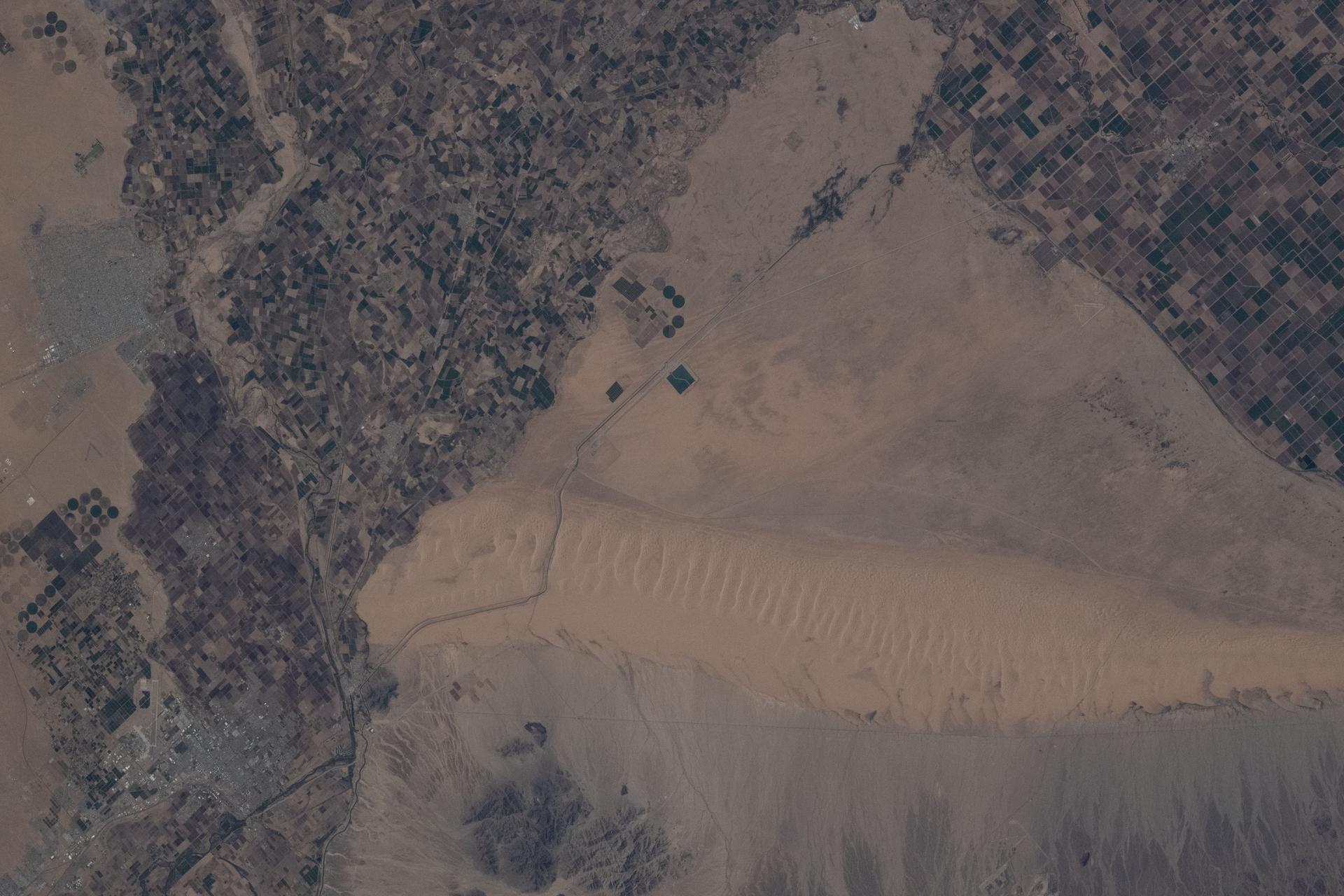 The Mexico–United States border separates Baja California (left) on the Mexican side from California (right) on the U.S. side in this photograph from the International Space Station as it orbited 261 miles above. This region is part of the Sonoran Desert, with the Algodones Dunes prominently visible on the U.S. side. Near upper left, is the Mexican city of San Luis RĂo Colorado with a population of about 177,000.